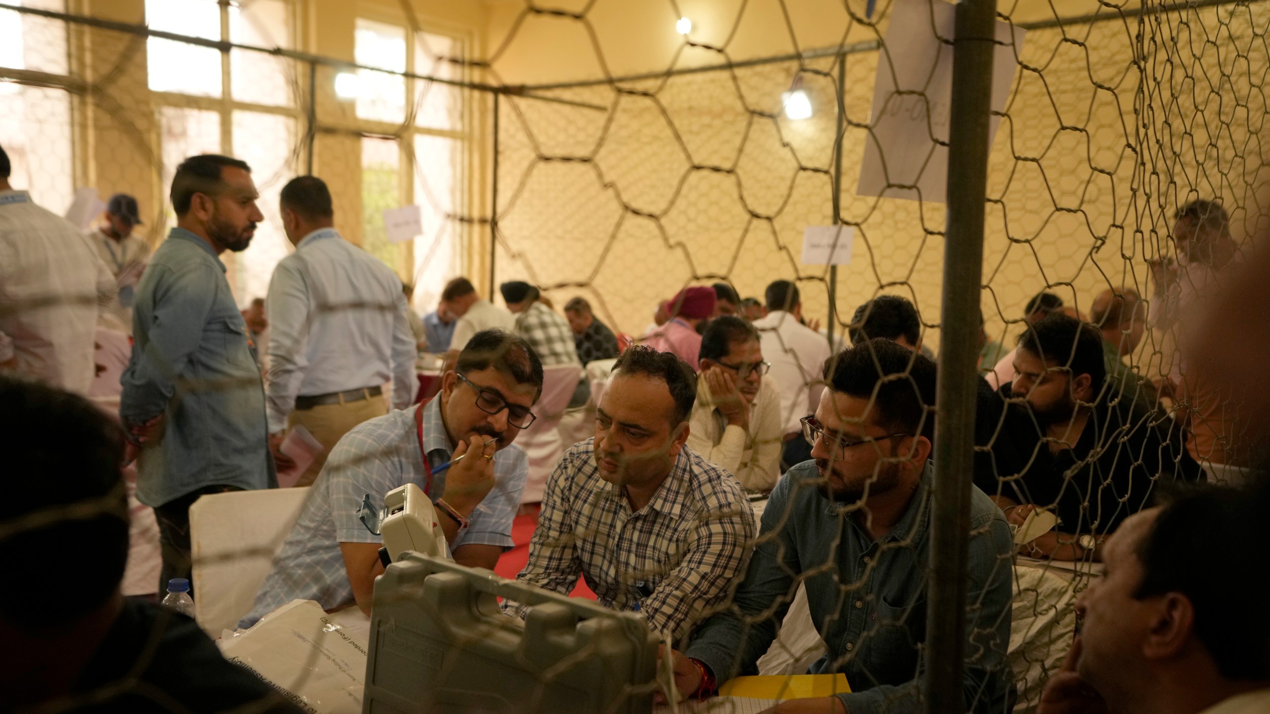 Election officers count votes for the recent election at a counting center in Jammu, India, Tuesday, Oct. 8, 2024. (AP Photo/Channi Anand)