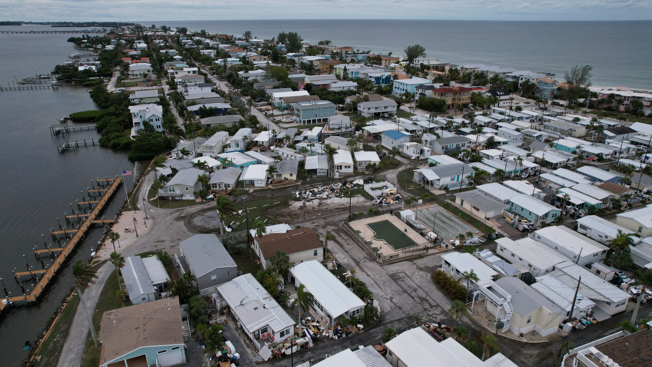 Destroyed furniture and personal items from Hurricane Helene flooding sit piled outside mobile homes in the Sandpiper Resort Co-op ahead of the arrival of Hurricane Milton in Bradenton Beach on Anna Maria Island, Fla., Tuesday, Oct. 8, 2024. (AP Photo/Rebecca Blackwell)