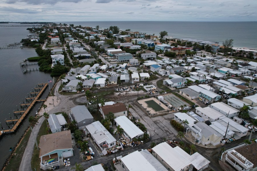 Destroyed furniture and personal items from Hurricane Helene flooding sit piled outside mobile homes in the Sandpiper Resort Co-op ahead of the arrival of Hurricane Milton in Bradenton Beach on Anna Maria Island, Fla., Tuesday, Oct. 8, 2024. (AP Photo/Rebecca Blackwell)