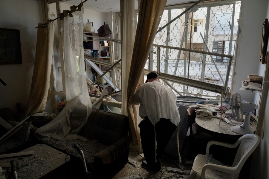 A man examine his damaged apartment that was hit by a rocket fired from Lebanon, in Kiryat Yam, northern Israel, on Tuesday, Oct. 8, 2024. (AP Photo/Ariel Schalit)