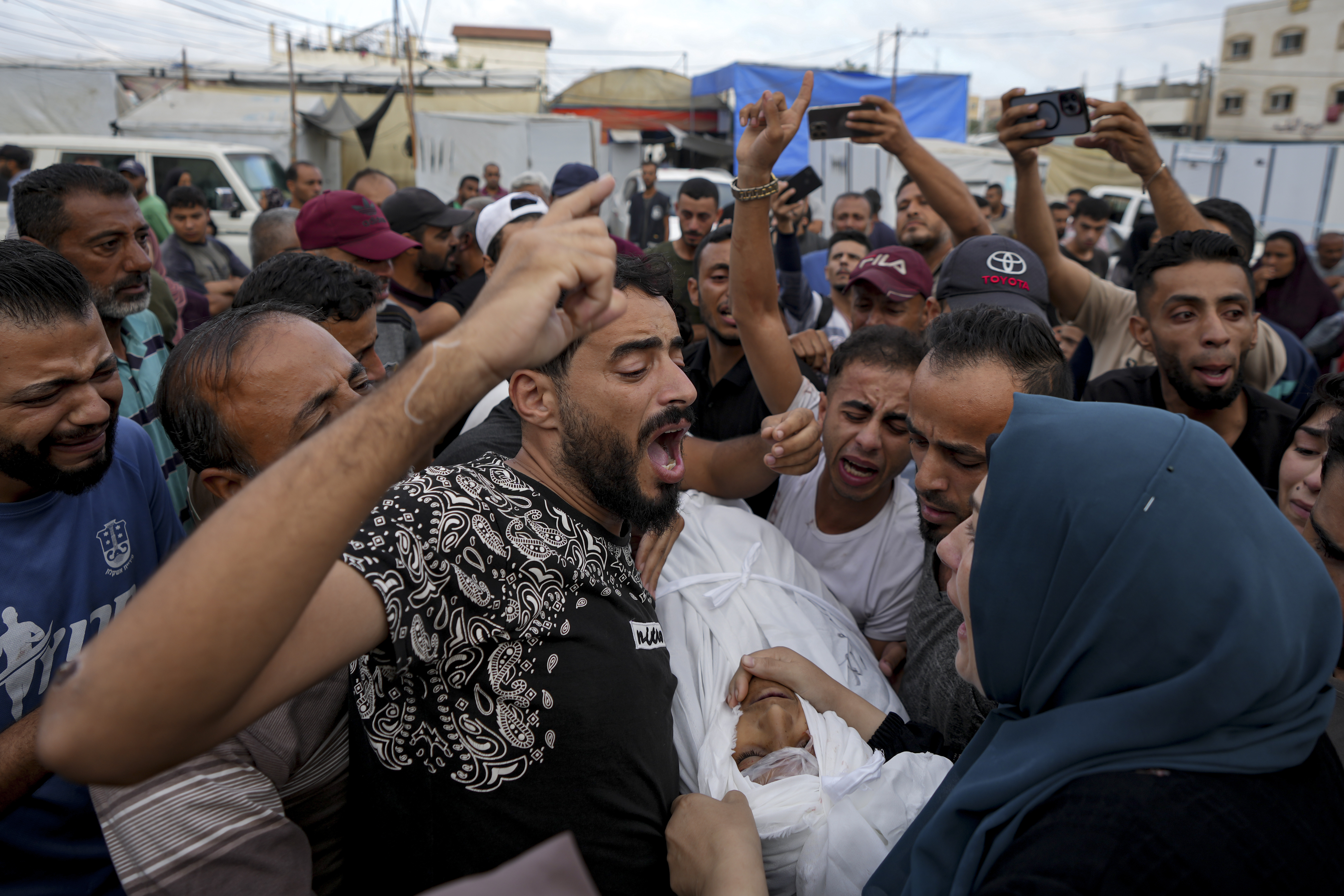 Palestinians mourn a relative killed in the Israeli bombardment of the Gaza Strip at a hospital in Deir al-Balah, Tuesday, Oct. 8, 2024. (AP Photo/Abdel Kareem Hana)