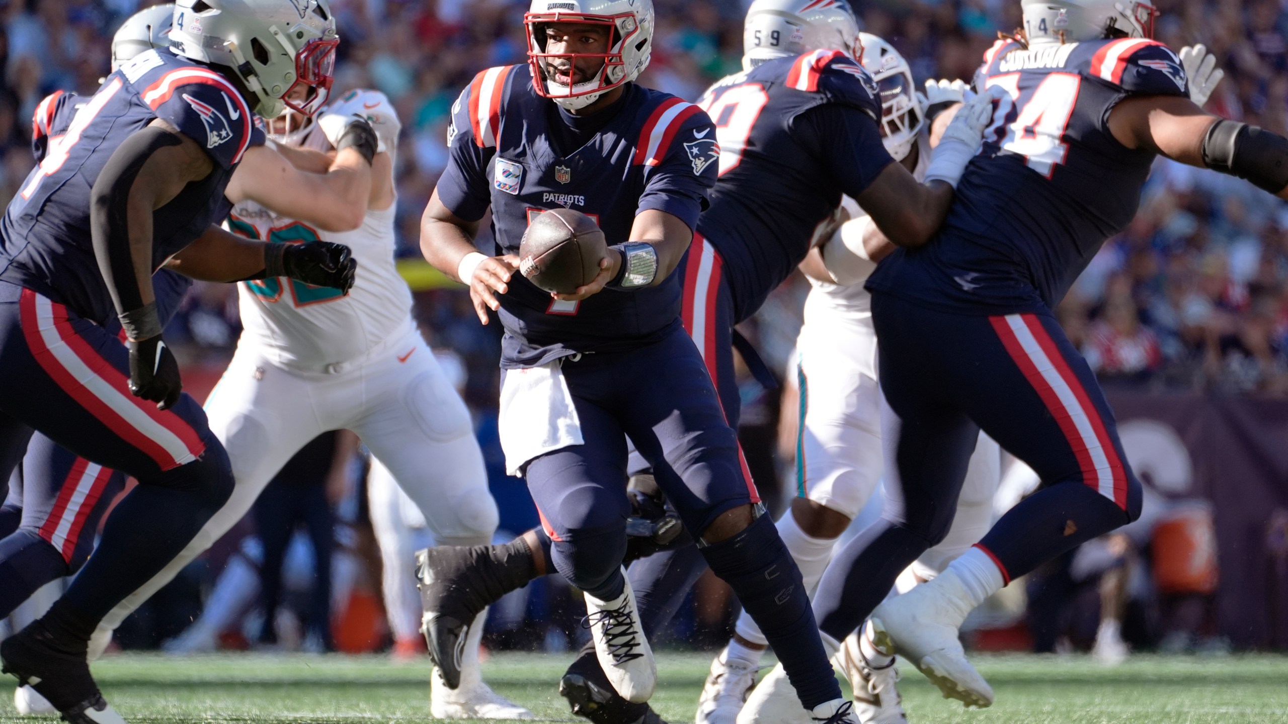 New England Patriots quarterback Jacoby Brissett, center, sets to hand off the ball against the Miami Dolphins during the second half of an NFL football game, Sunday, Oct. 6, 2024, in Foxborough, Mass. (AP Photo/Michael Dwyer)