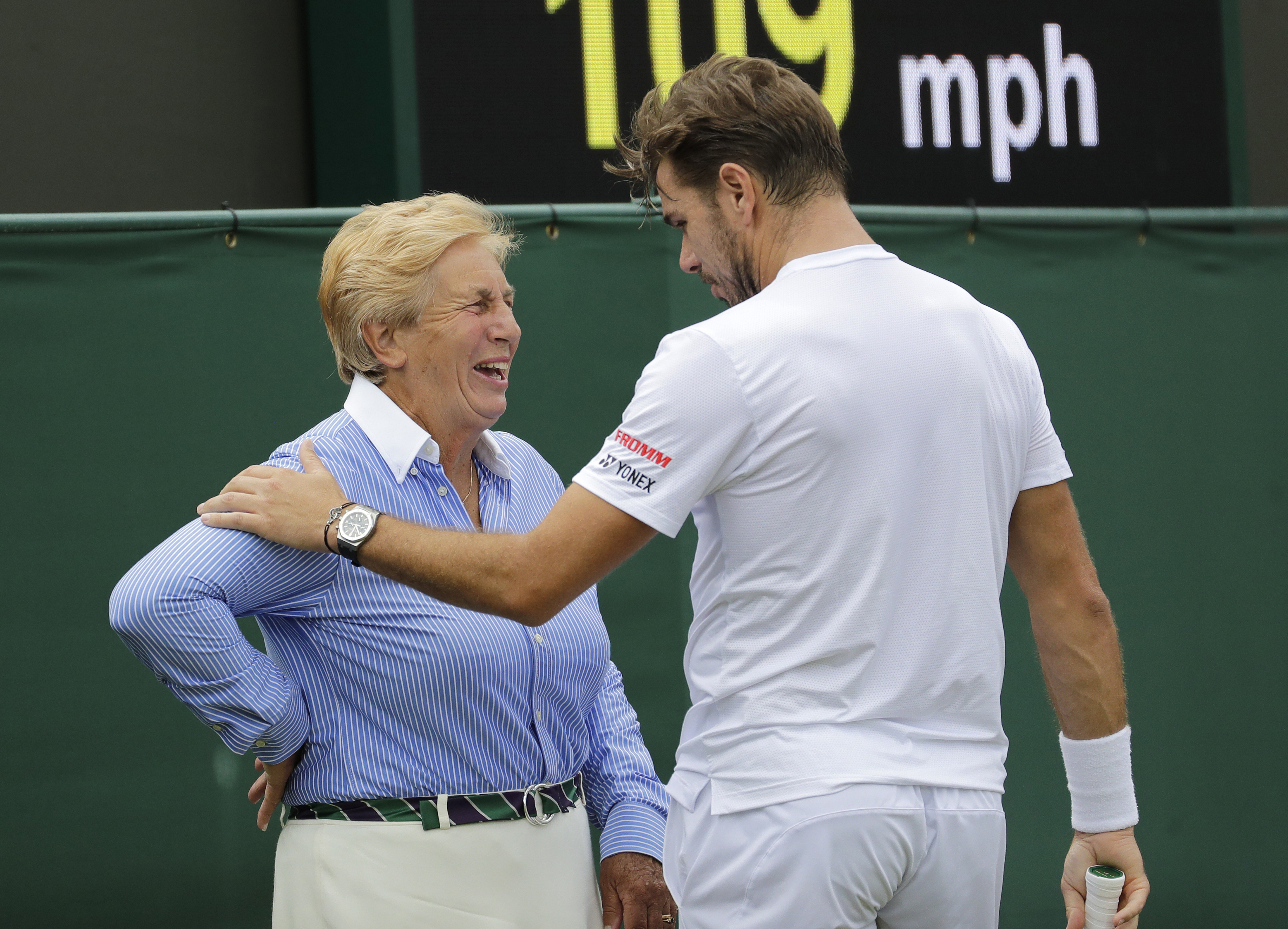 FILE - Switzerland's Stan Wawrinka jokes with a line judge in his Men's singles match against United States' Reilly Opelka during the Wimbledon Tennis Championships in London, Wednesday, July 3, 2019. That long-held Wimbledon tradition of line judges dressed in elegant uniforms is no more. The All England Club has announced that artificial intelligence will be used to make the 'out' and 'fault' calls at the championships from 2025.(AP Photo/Ben Curtis, File)