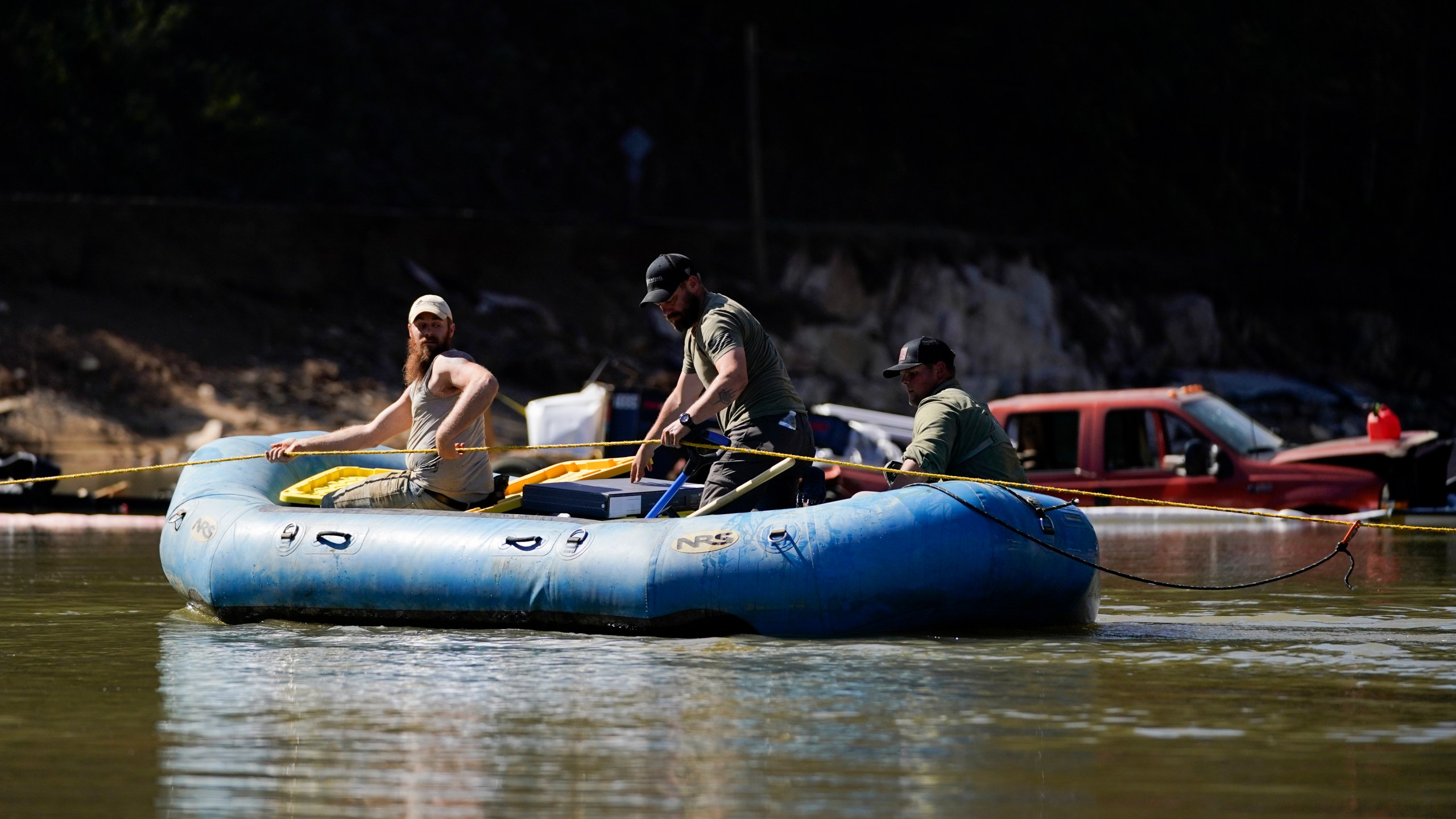 Civilian volunteers using an inflatable raft deliver supplies to residents in the aftermath of Hurricane Helene, Tuesday, Oct. 8, 2024, in Burnsville, N.C. (AP Photo/Erik Verduzco)