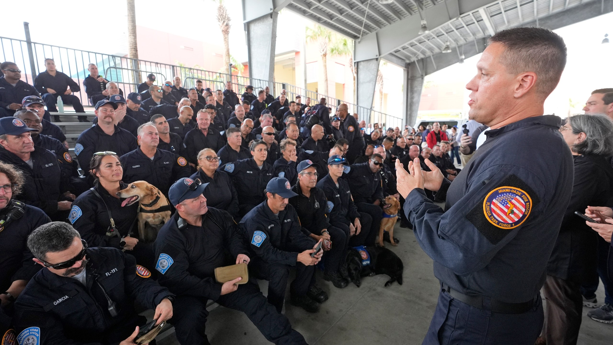 Miami-Dade Fire Rescue's Urban Search and Rescue Florida Task Force One leader Brandon Webb, right, addresses members of the task force before they deploy ahead of Hurricane Milton, Wednesday, Oct. 9, 2024, in Doral, Fla. (AP Photo/Wilfredo Lee)