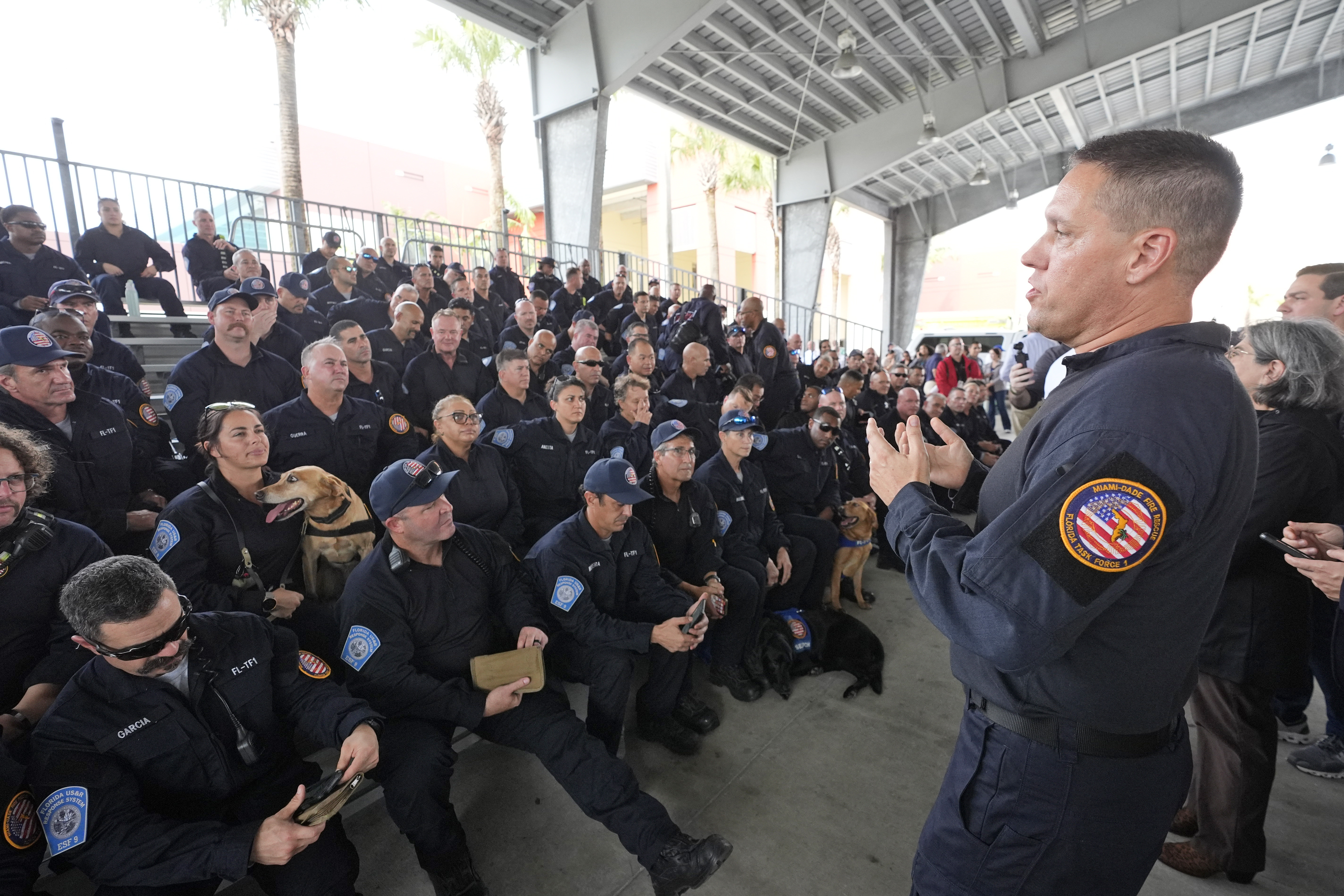 Miami-Dade Fire Rescue's Urban Search and Rescue Florida Task Force One leader Brandon Webb, right, addresses members of the task force before they deploy ahead of Hurricane Milton, Wednesday, Oct. 9, 2024, in Doral, Fla. (AP Photo/Wilfredo Lee)