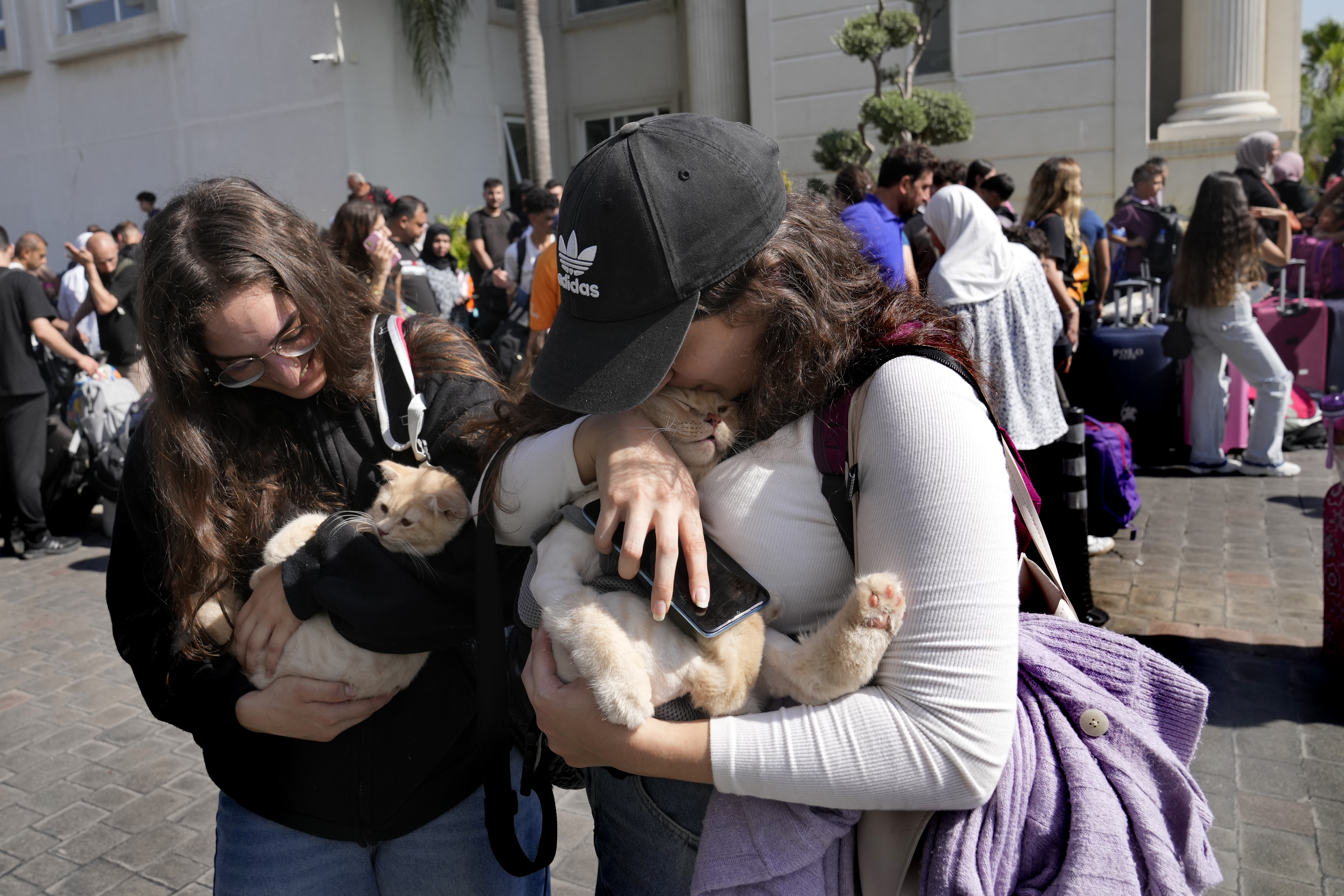 Turkish citizens carry their cats as they wait to board a Turkish navy vessel to be evacuated to Turkey at a gathering point, in Beirut, Lebanon, Wednesday, Oct. 9, 2024. (AP Photo/Hussein Malla)