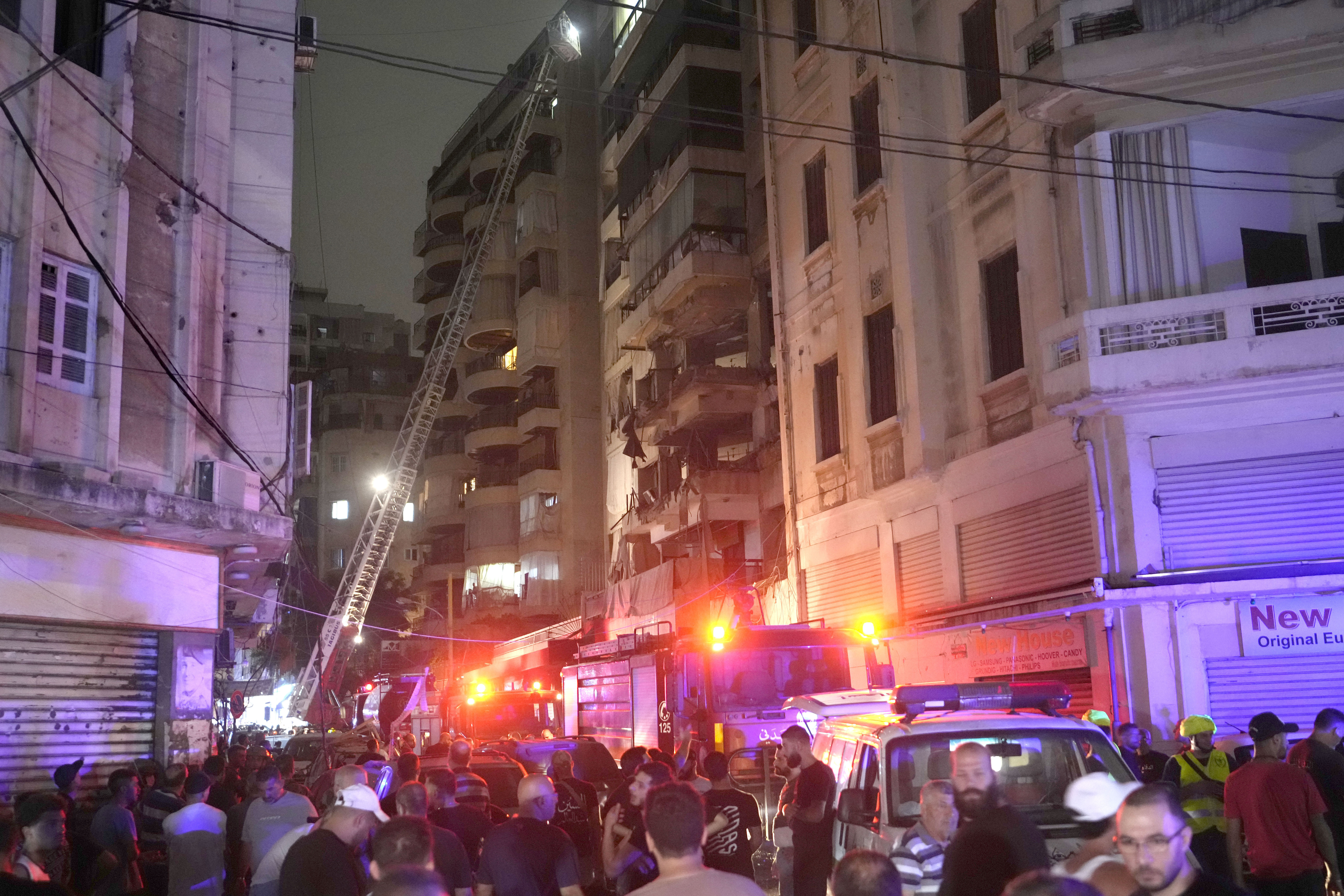 Rescue workers on a crane check a destroyed building hit by an Israeli airstrike in central Beirut, Lebanon, Thursday, Oct. 10, 2024. (AP Photo/Hassan Ammar)