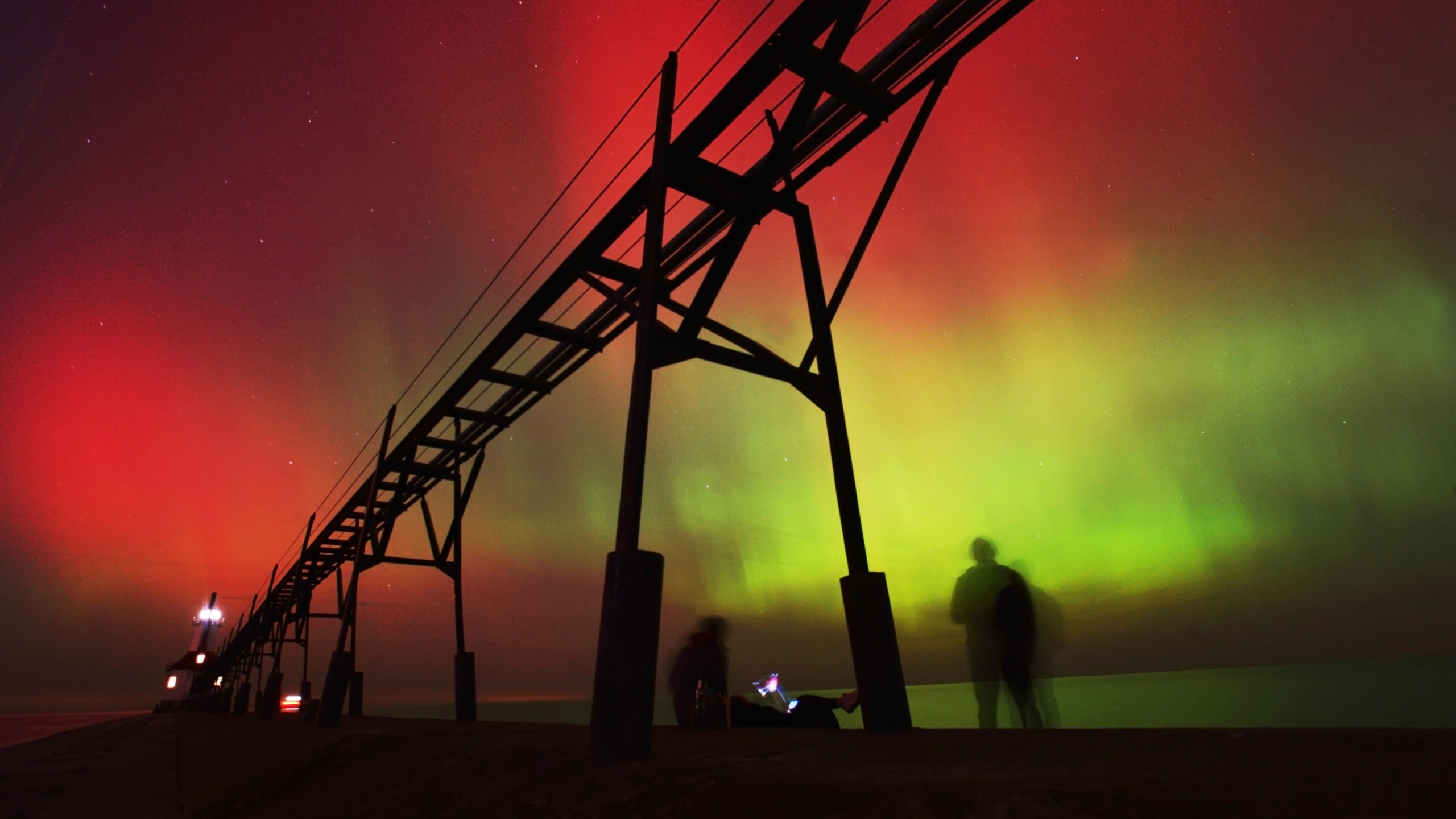 An aurora borealis, also known as the northern lights, lights up the night sky off Lake Michigan and the St. Joseph Lighthouse, Thursday, Oct. 10, 2024, in St. Joseph, Mich. (Don Campbell/The Herald-Palladium via AP)