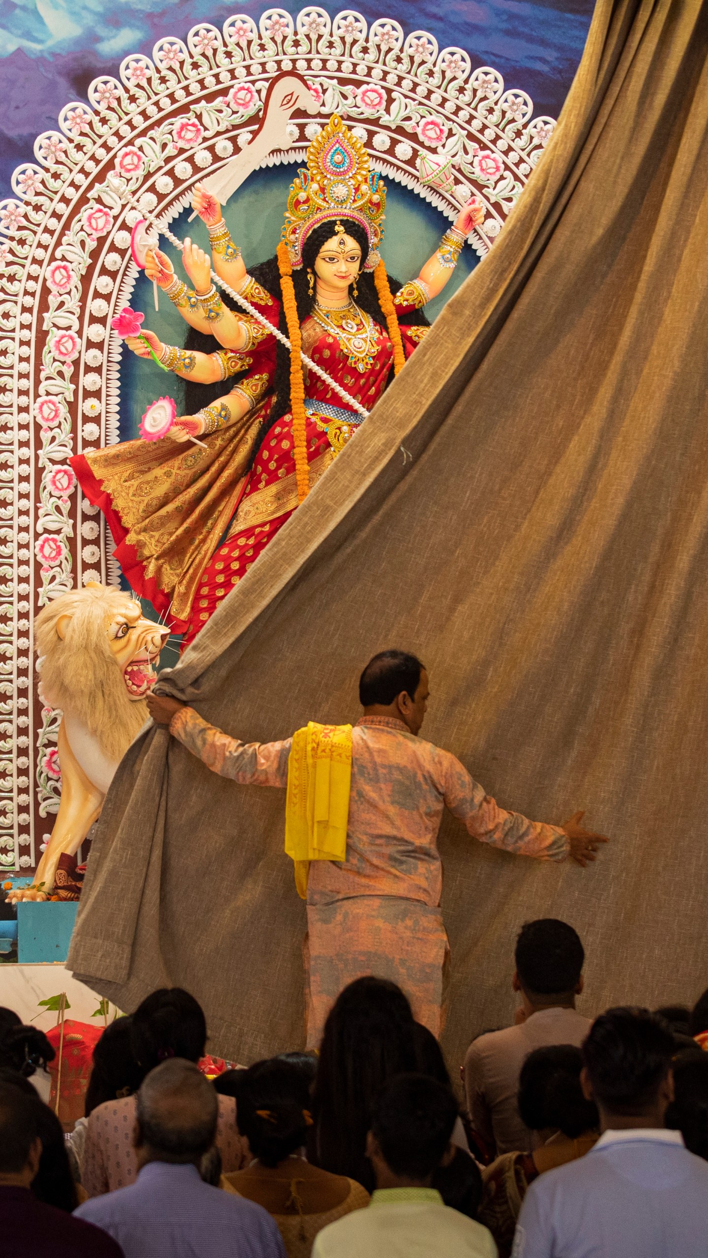 A priest opens the curtain of a tableau depicting an idol of Hindu goddess Durga at Dhakeshwari National Temple during the Durgapuja festival in Dhaka, Bangladesh, on Oct. 10, 2024. (AP Photo/Rajib Dhar)