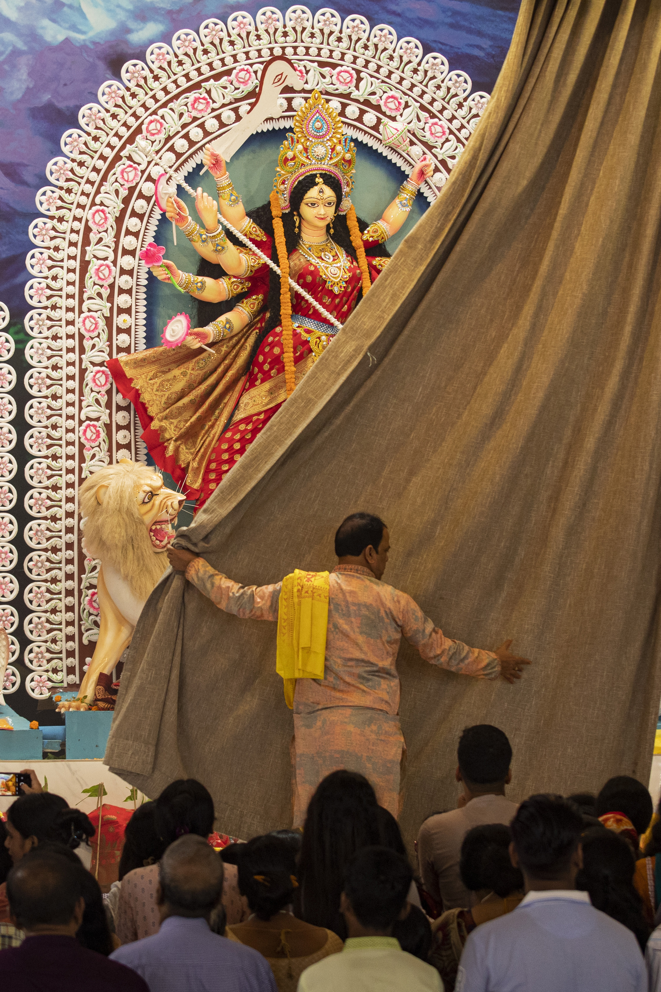 A priest opens the curtain of a tableau depicting an idol of Hindu goddess Durga at Dhakeshwari National Temple during the Durgapuja festival in Dhaka, Bangladesh, on Oct. 10, 2024. (AP Photo/Rajib Dhar)