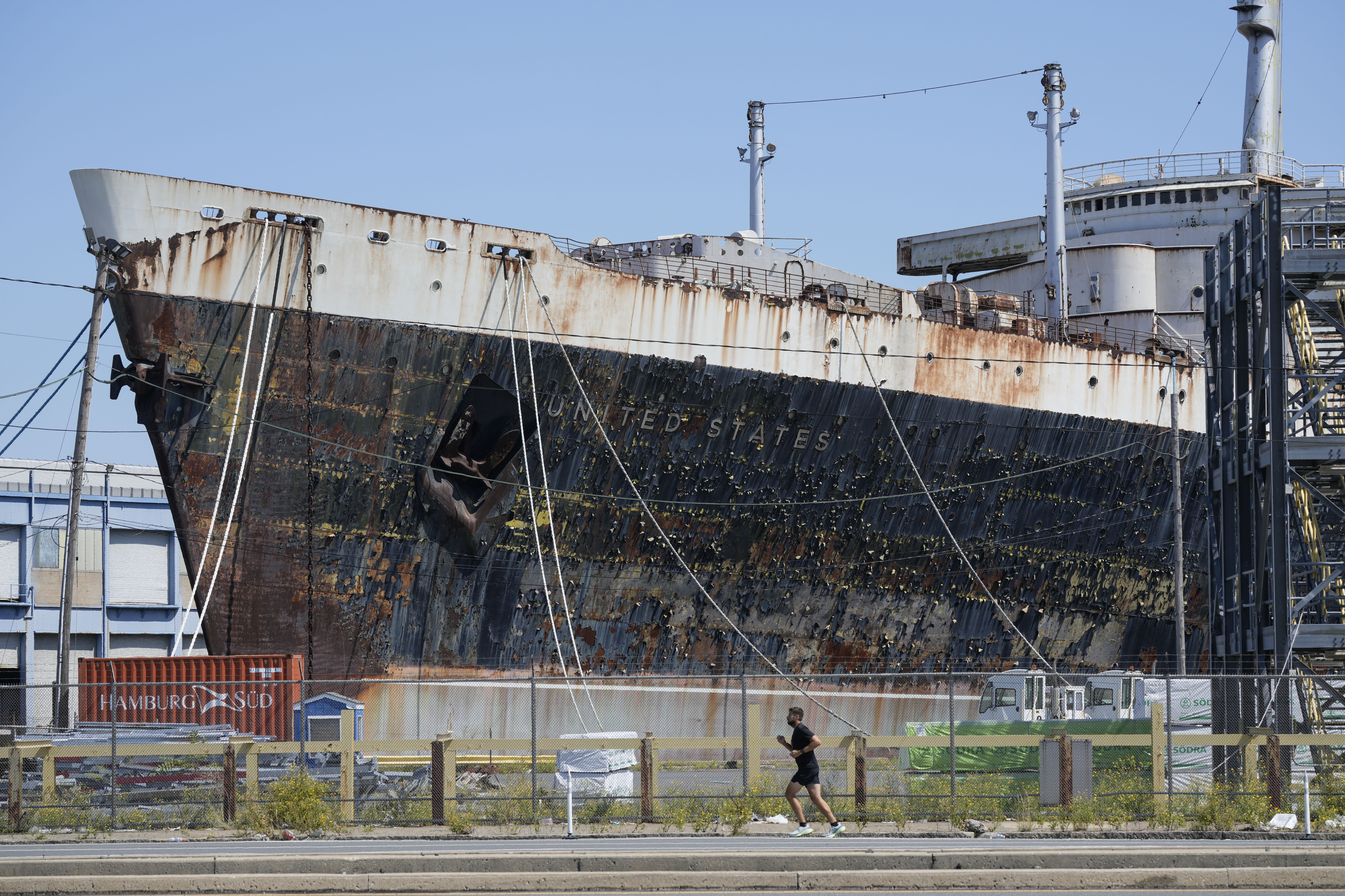 FILE - A person runs past the S.S. United States moored on the Delaware River in Philadelphia, Sept. 4, 2024. (AP Photo/Matt Rourke, File)