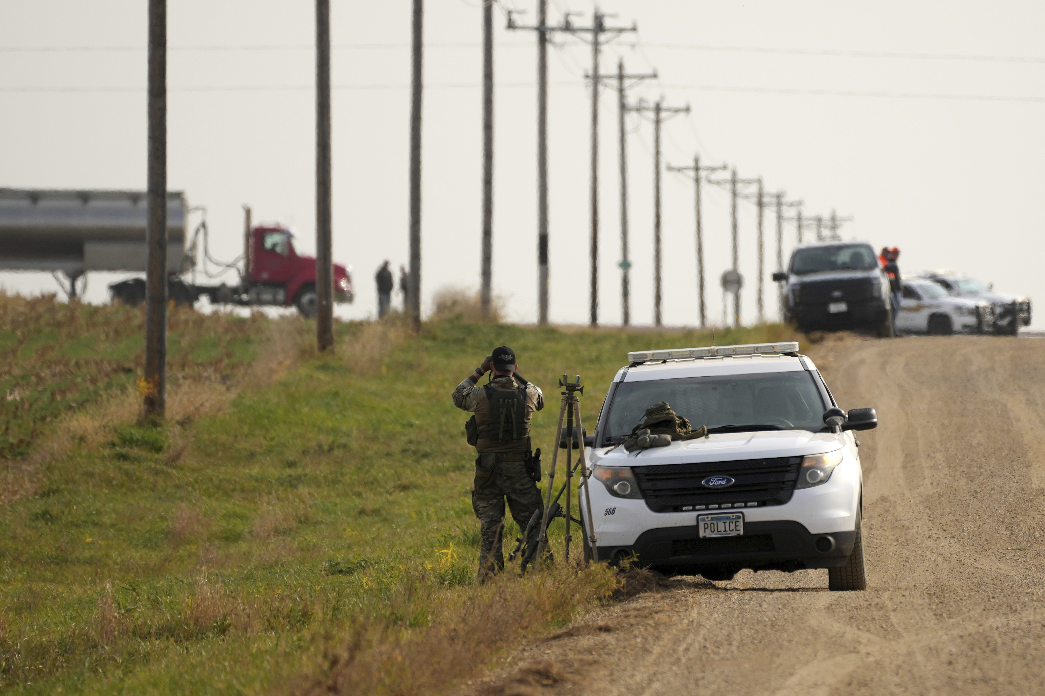 Local police and Secret Service agents surround the area as Tim Walz, Minnesota governor and Democratic vice presidential candidate, takes part in the annual Minnesota Governor's Pheasant Hunting Opener near Sleepy Eye, Minn., Saturday, Oct. 12, 2024. (Anthony Souffle/Star Tribune via AP)