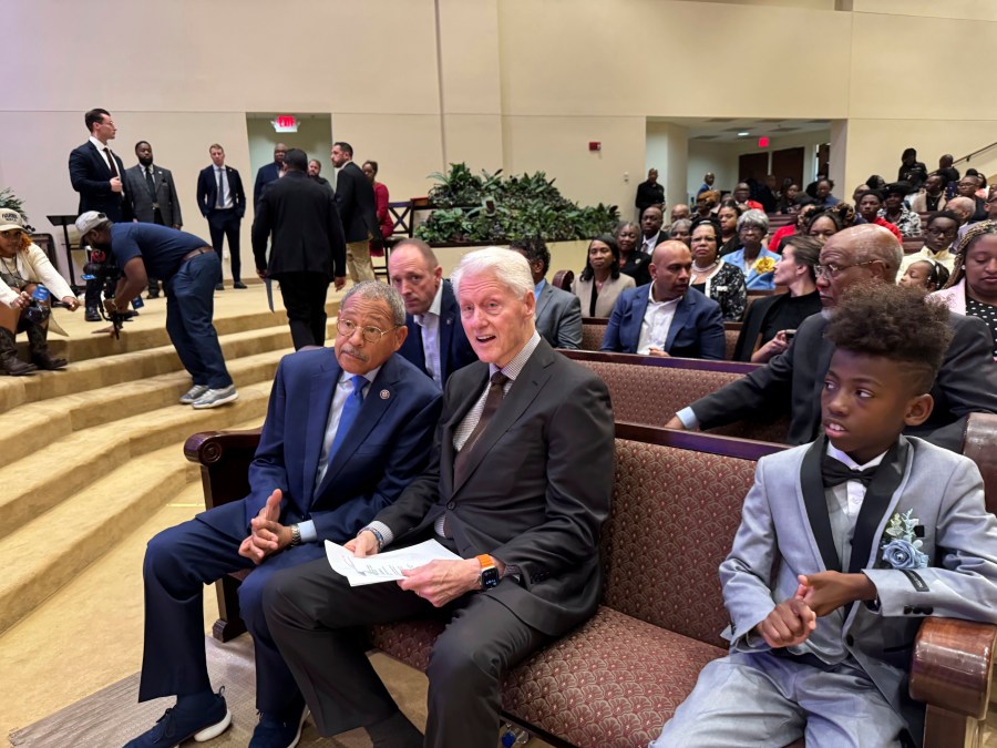 Former President Bill Clinton and U.S. Congressman Sanford Bishop talk at Mt. Zion Baptist Church in Albany, Ga. on Sunday, Oct. 13, 2024. (AP Photo/Charlotte Kramon)