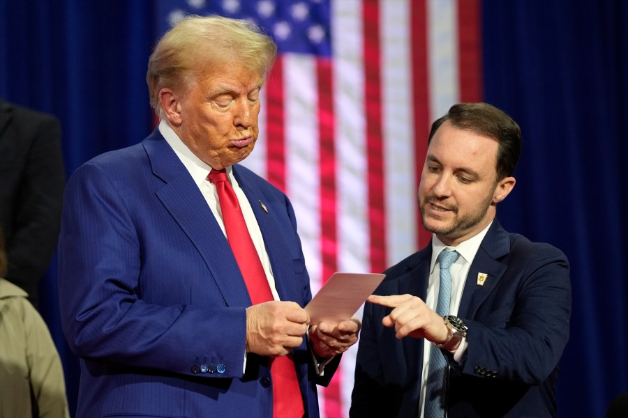 Republican presidential nominee former President Donald Trump reads a note that Justin Caporale brought onto the stage at a campaign town hall at the Greater Philadelphia Expo Center & Fairgrounds, Monday, Oct. 14, 2024, in Oaks, Pa. (AP Photo/Alex Brandon)