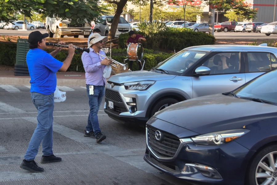 Musicians play for tips from motorists in Culiacan, Sinaloa state, Mexico, Monday, Oct. 14, 2024. (AP Photo)