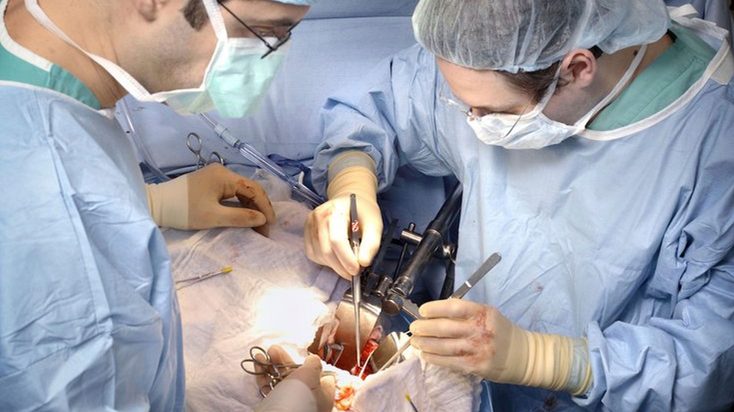 In this photo provided by Johns Hopkins Medicine, Dr. Dorry Segev, right, performs the first U.S. transplant of a kidney from a deceased donor who had HIV into a recipient living with HIV, in Baltimore, in March 2016. (Johns Hopkins Medicine via AP)