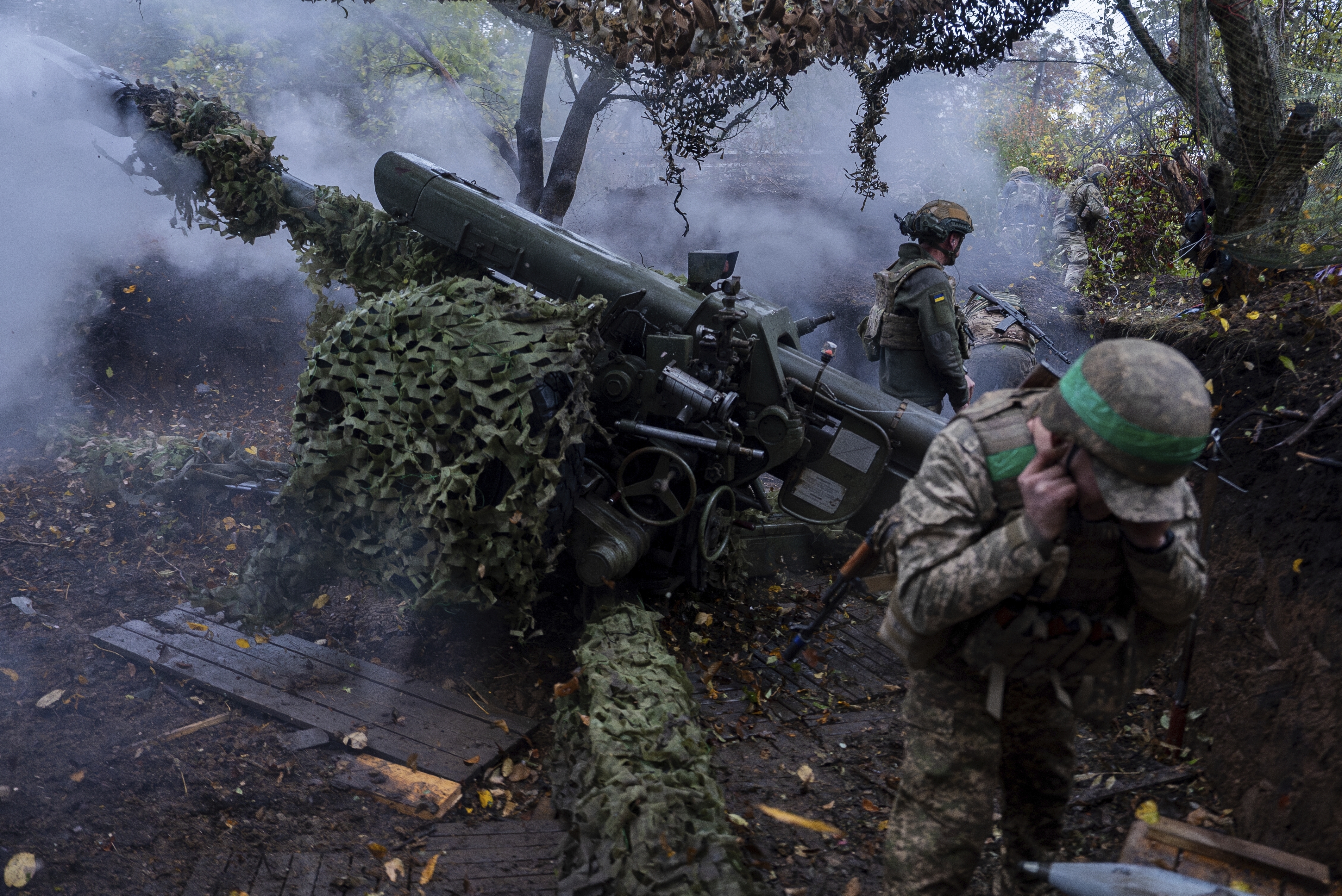 Ukrainian servicemen of Khartia brigade fire D-30 Howitzer towards Russian positions in Kharkiv region, Ukraine, Wednesday, Oct. 16, 2024. (AP Photo/Alex Babenko)