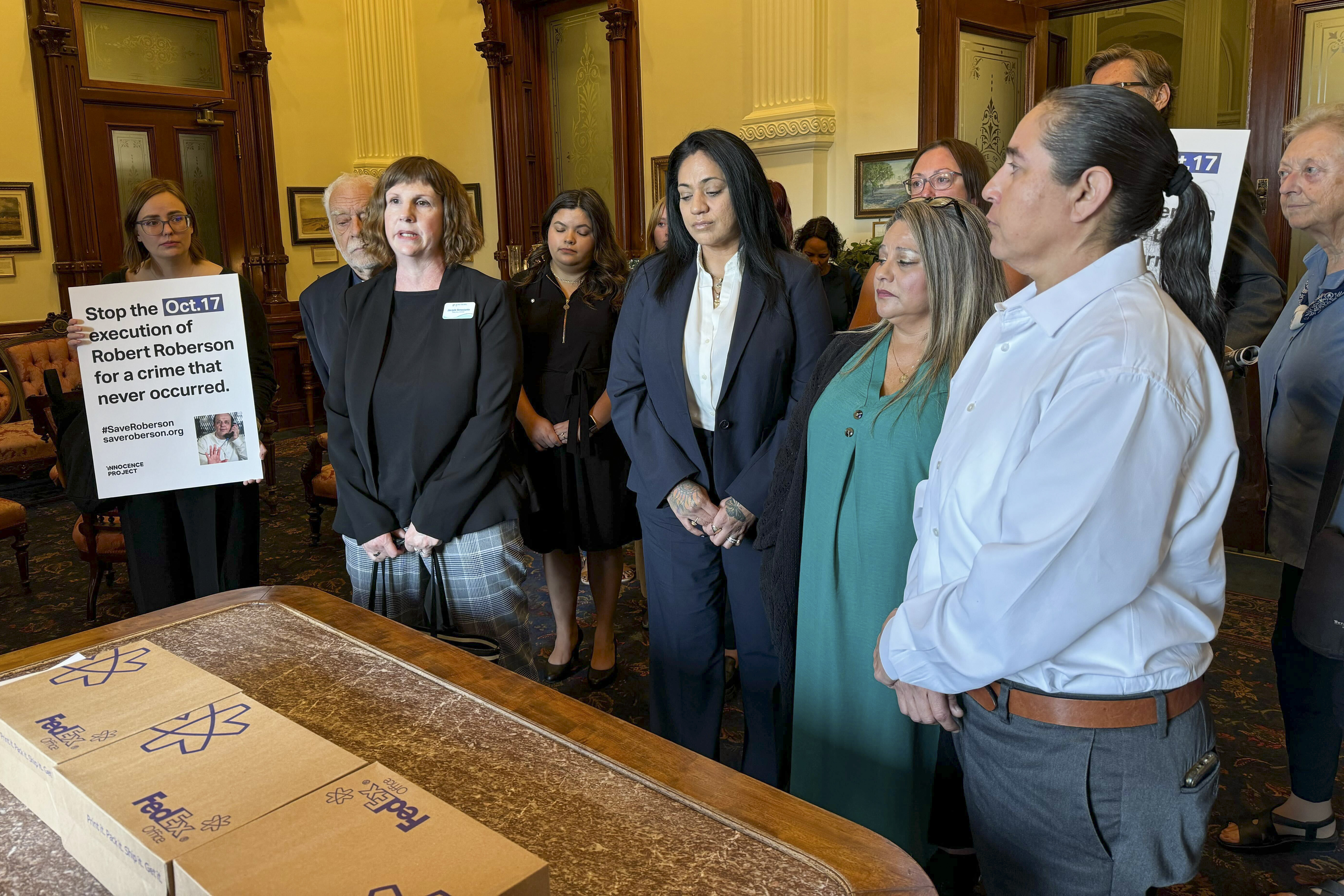 Elizabeth Ramirez, center, Casandra Rivera, center right, and Anna Vasquez, second from right, of the "San Antonio 4" group, deliver boxes with petitions in the Texas State capitol for Texas Gov. Greg Abbott seeking the pardoning of Robert Roberson's execution, Wednesday, Oct. 16, 2024, in Austin, Texas. Roberson, 57, is scheduled to receive a lethal injection on Oct. 17, for the 2002 killing of his 2-year-old daughter, Nikki Curtis, in the East Texas city of Palestine. Roberson has long proclaimed his innocence. (AP Photo/Nadia Lathan)