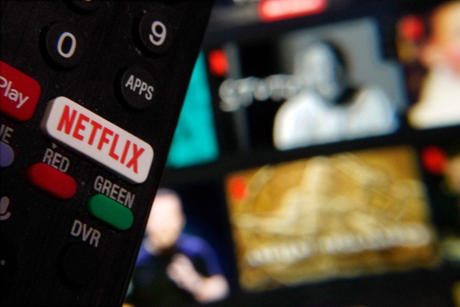 FILE - The Netflix button on a television remote control was juxtaposed with a Netflix web page, in this photo in New York, Feb. 2, 2023. (AP Photo/Richard Drew, File)