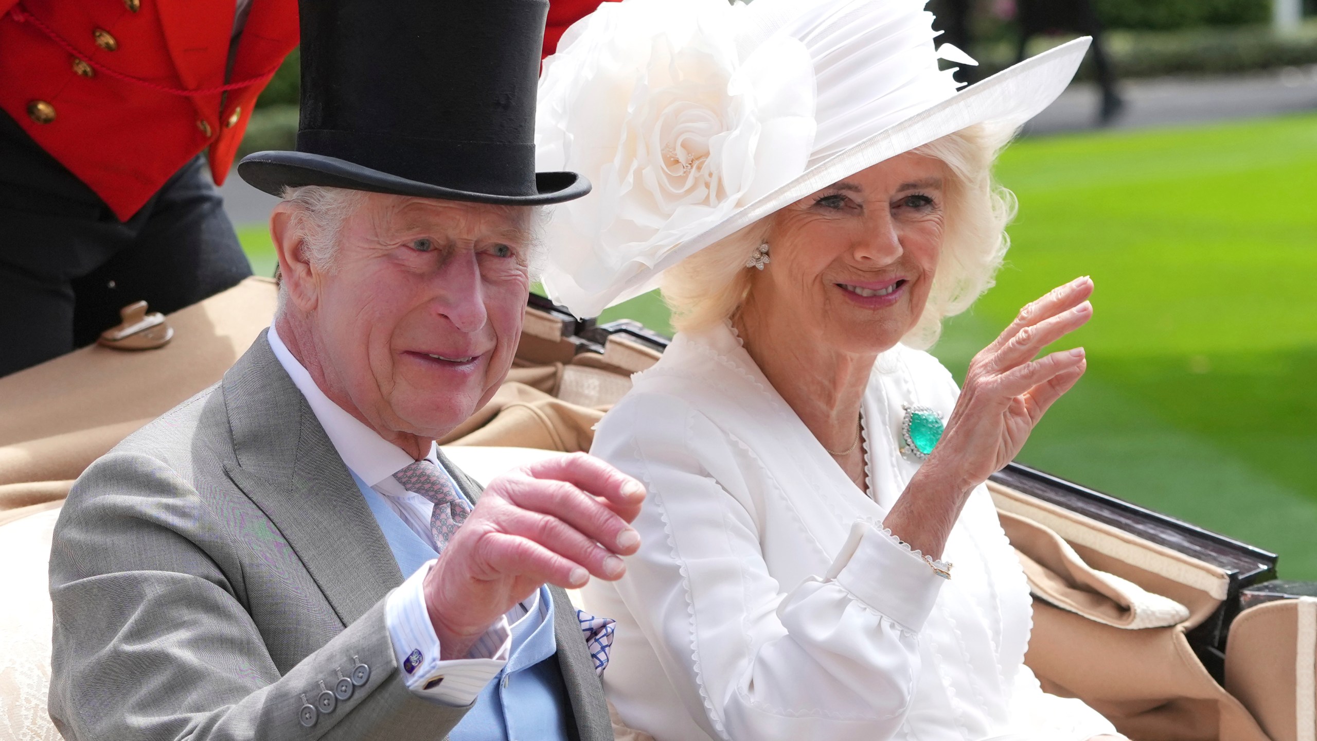 FILE - Britain's King Charles III and Queen Camilla wave to the crowds as they arrive by carriage in the parade ring on the third day of the Royal Ascot, horse race meeting, traditional known as Ladies Day, at Ascot, England, on June 20, 2024. (AP Photo/Kin Cheung, File)