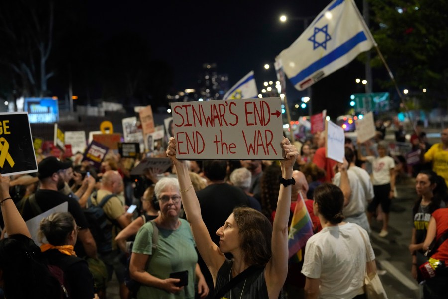 A demonstrator holds a sign about the killing of Hamas leader Yahya Sinwar during a protest calling for a cease-fire deal and the immediate release of hostages held by Hamas on Thursday, Oct. 17, 2024, in Tel Aviv, Israel. (AP Photo/Ariel Schalit)