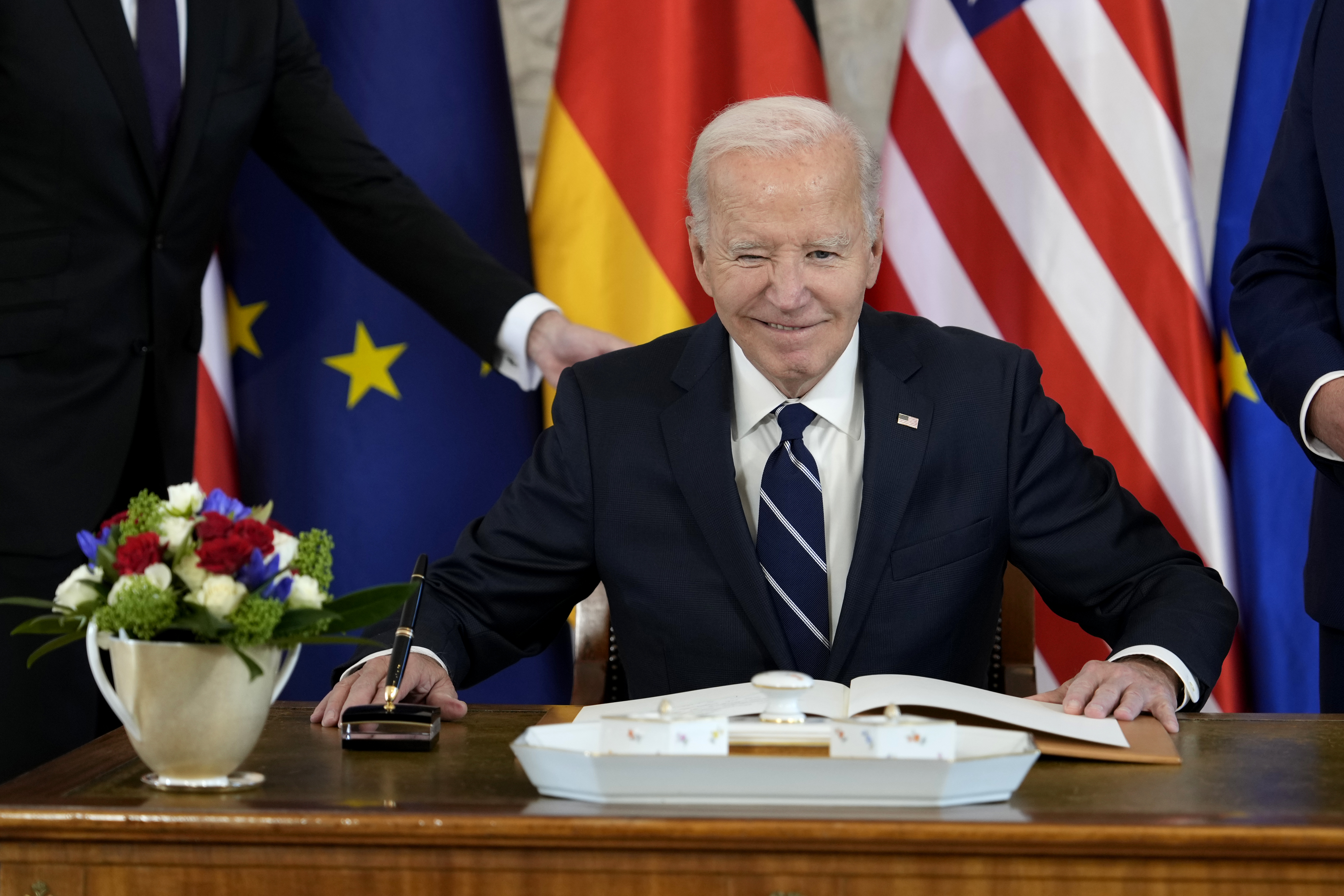 President Joe Biden signs a guest book during the welcoming ceremony at Bellevue Palace in Berlin, Germany, Friday, Oct. 18, 2024. (AP Photo/Ben Curtis)