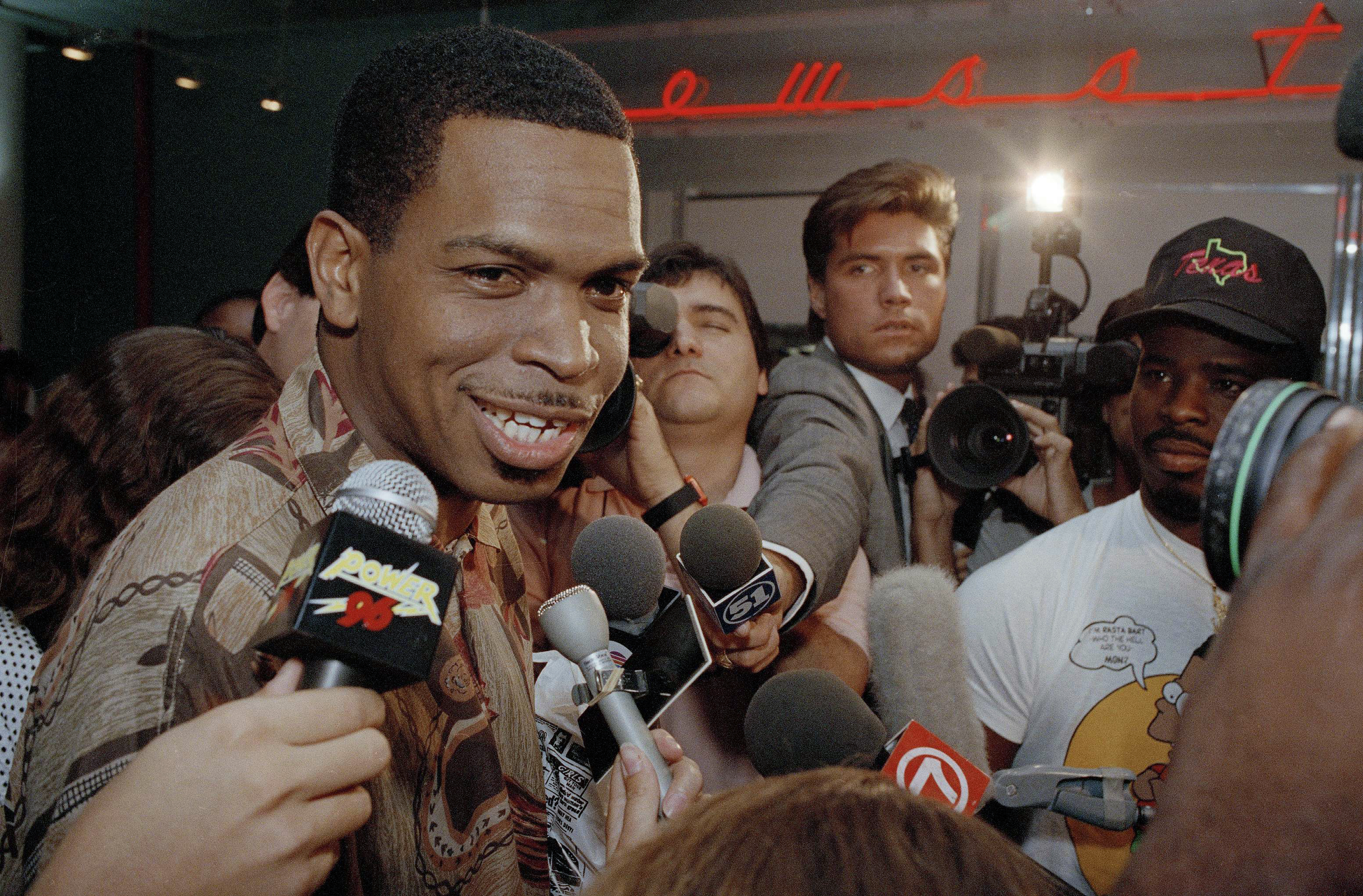 FILE - Luther Campbell, aka Luke Skyywalker, lead singer of the rap group 2 Live Crew is surrounded by a sea of microphones after meeting other band members at Miami International Airport, June 11, 1990. (AP Photo/Chris O'Meara, File)