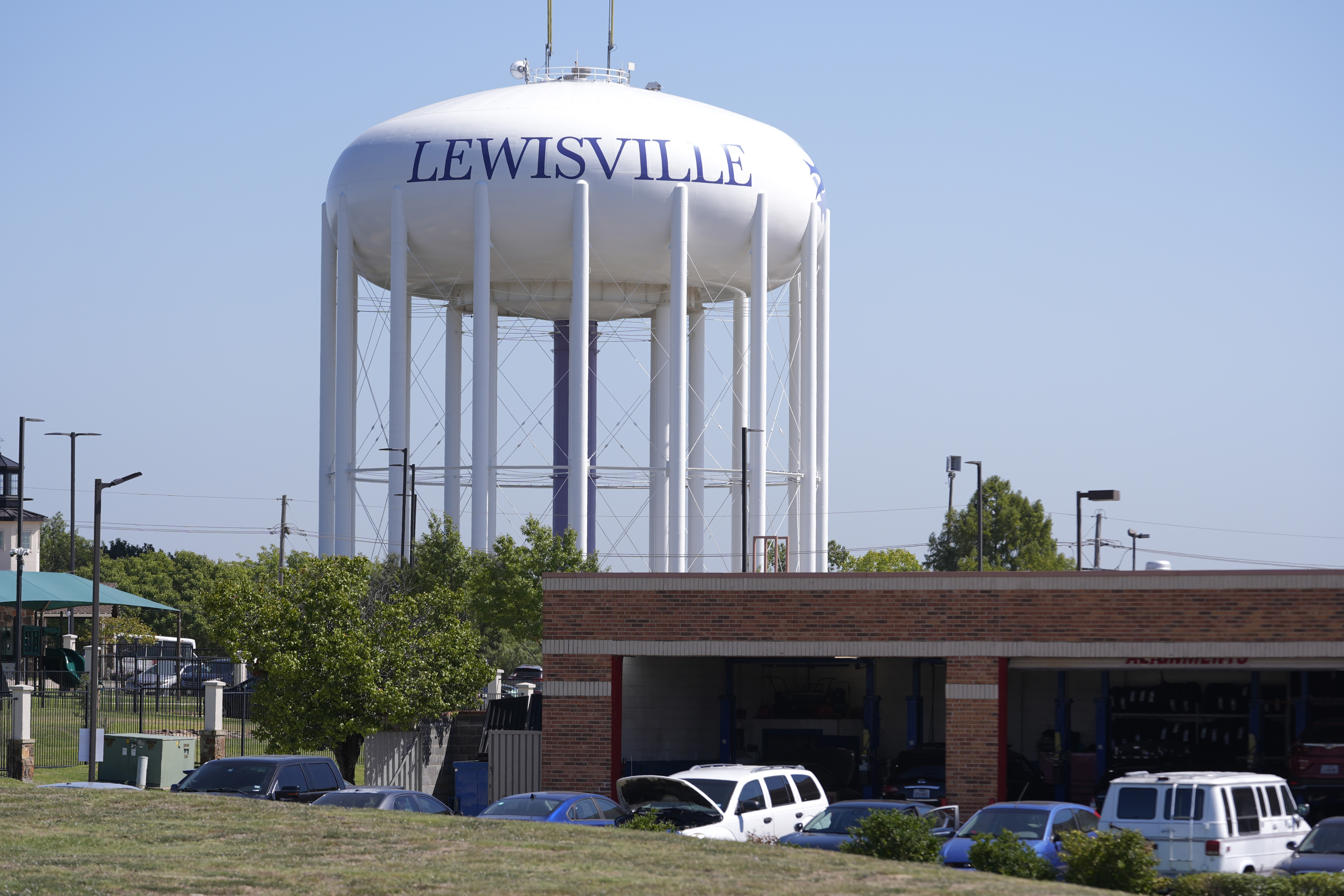 A water tower sits near businesses in Lewisville, Texas, Wednesday, Oct. 2, 2024. (AP Photo/LM Otero)