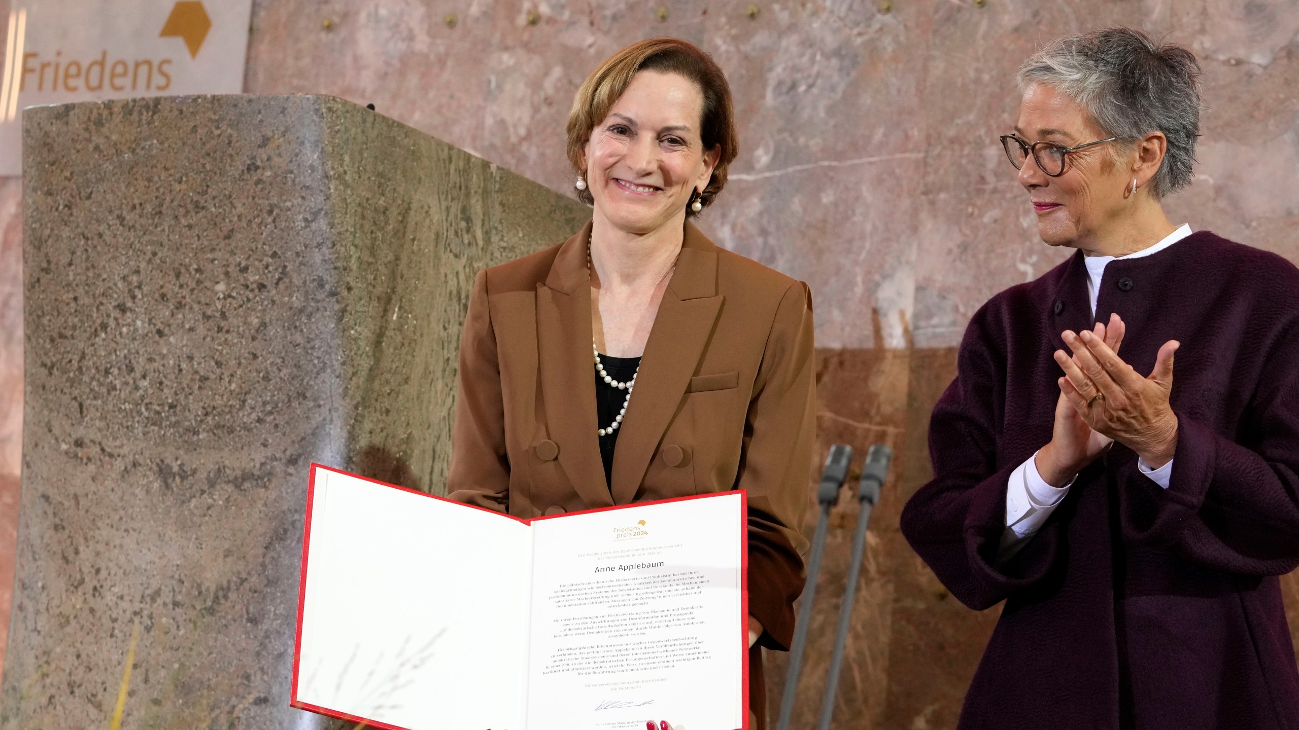 American journalist and historian Anne Applebaum, left, is awarded with the Peace Prize of the German Book Trade by Karin Schmidt-Friderichs, head of the German Publishers and Booksellers Association during a ceremony at the St. Paul's Church in Frankfurt, Germany, Sunday, Oct. 20, 2024.(AP Photo/Martin Meissner, Pool)