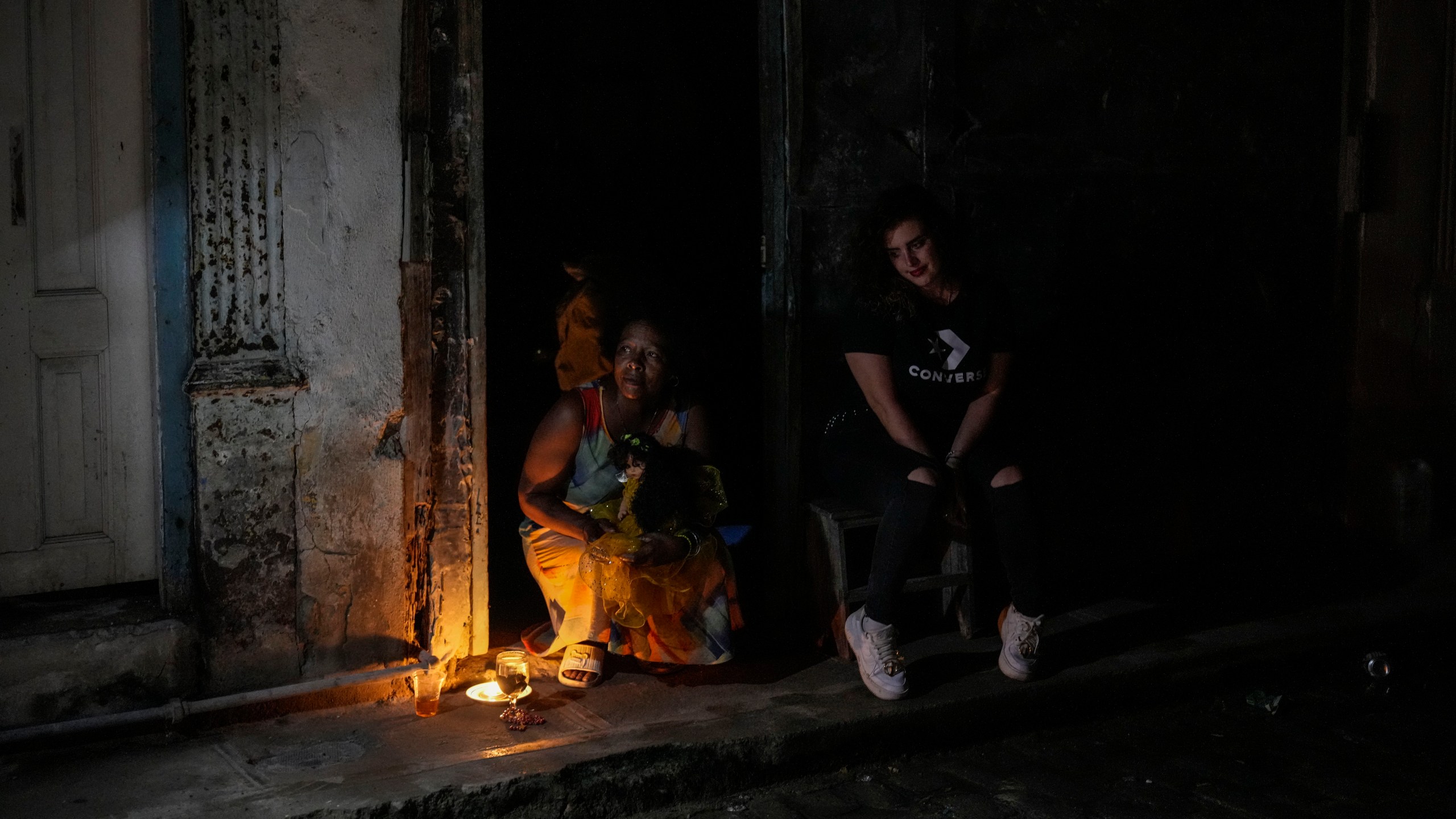 Residents pass the time during a blackout following the failure of a major power plant in Havana, Cuba, Saturday, Oct. 19, 2024. (AP Photo/Ramon Espinosa)