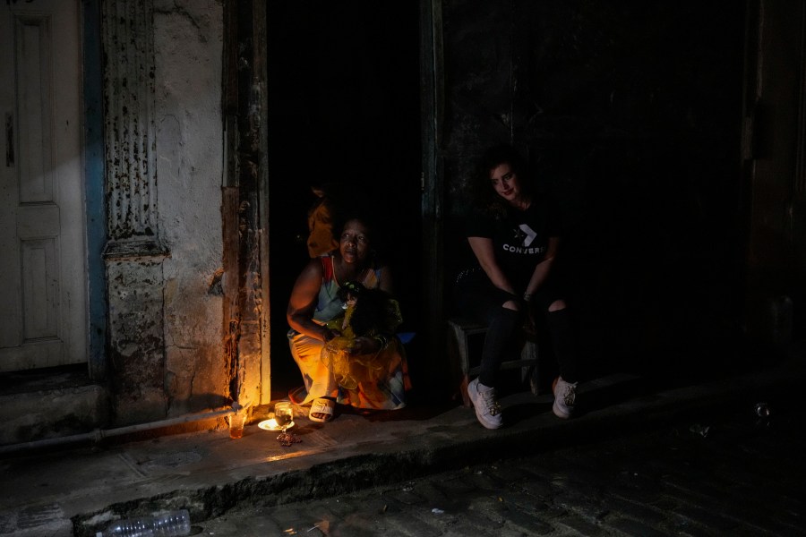 Residents pass the time during a blackout following the failure of a major power plant in Havana, Cuba, Saturday, Oct. 19, 2024. (AP Photo/Ramon Espinosa)