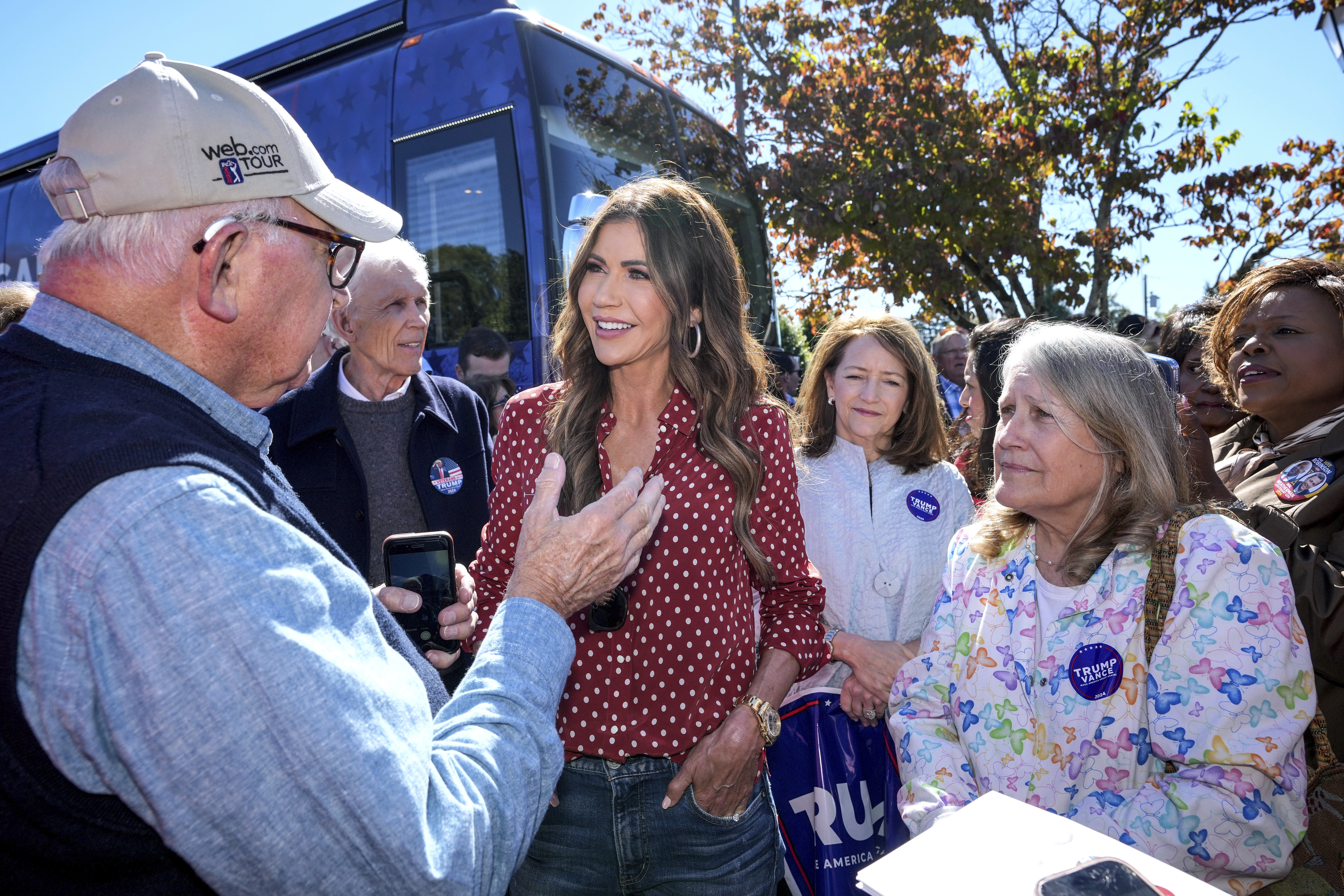 Governor Kristi Noel (SD), third from left, talks with Trump supporter, Tom Dodgen of Rutherfordton, left, at the Team Trump bus tour across North Carolina, Thursday, Oct. 17, 2024 in Rutherfordton, N.C. (AP Photo/Kathy Kmonicek)