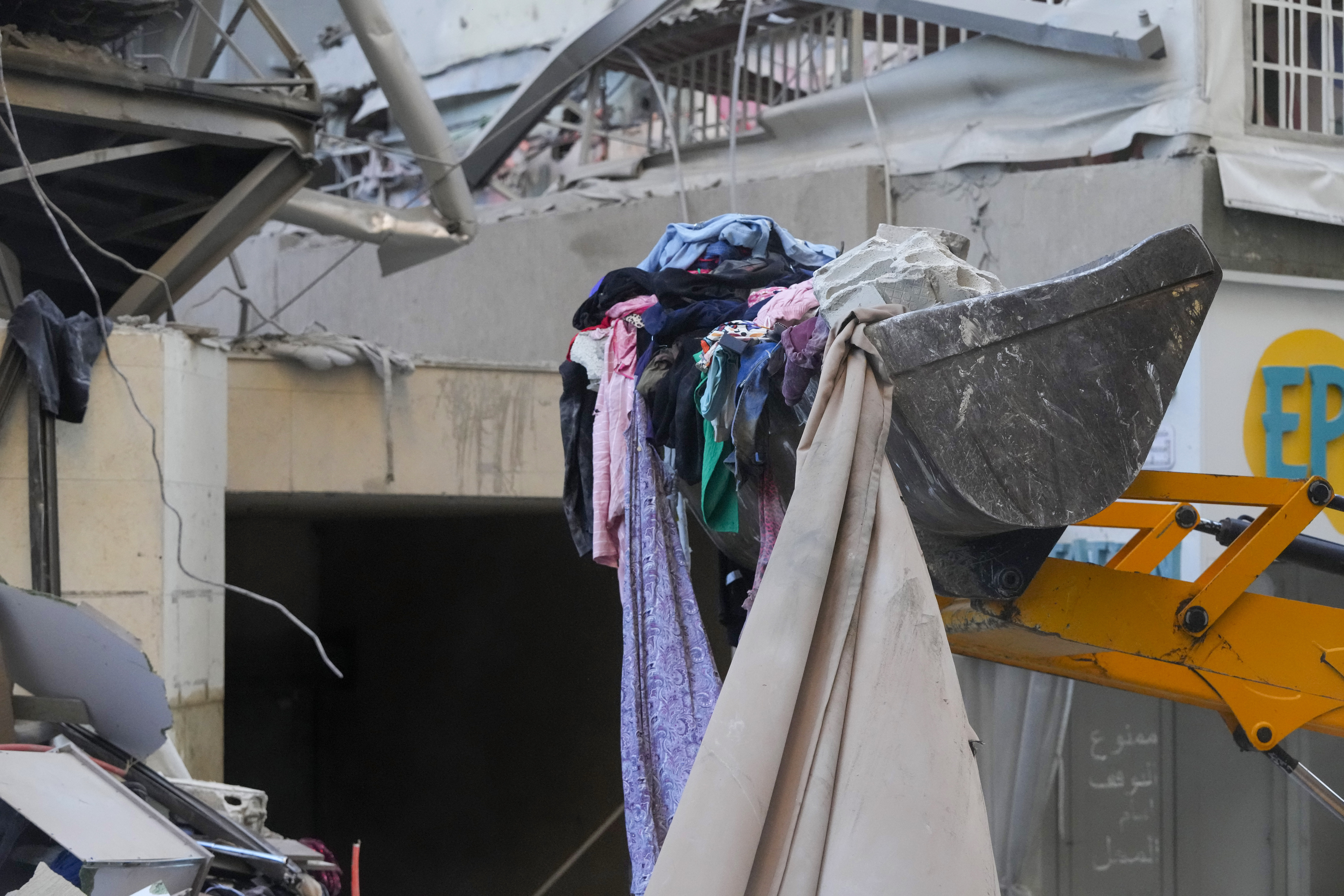 Rescue workers use a bulldozer to remove rubble of destroyed buildings at the site of an Israeli airstrike that hit several branches of the Hezbollah-run al-Qard al-Hassan in Dahiyeh, Beirut, Lebanon, Monday, Oct. 21, 2024. (AP Photo/Hassan Ammar)