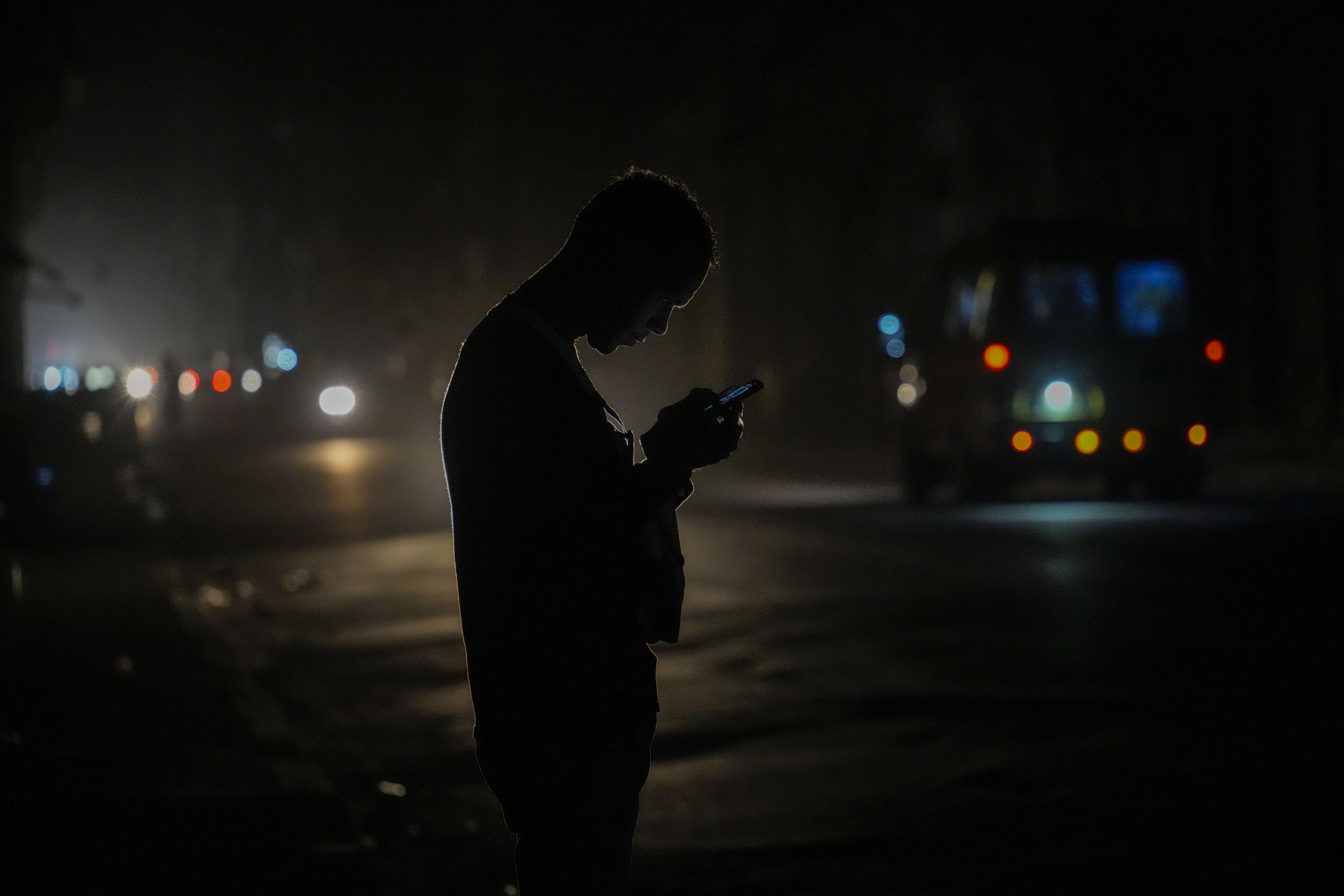 A resident looks at his cell phone on the street during a blackout following the failure of a major power plant in Havana, Cuba, Sunday, Oct. 20, 2024. (AP Photo/Ramon Espinosa)