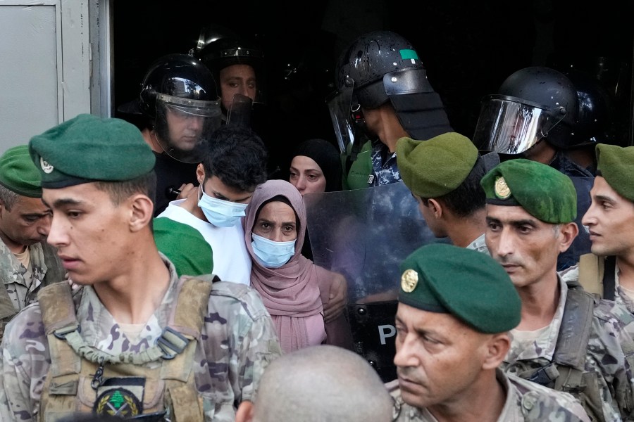 People displaced by Israel's war on Hezbollah leave a building after scuffle with members of the Lebanese security, after dozens of policemen arrived at the building to evict the displaced from the private property, in Beirut, Lebanon, Monday, Oct. 21, 2024. (AP Photo/Hassan Ammar)