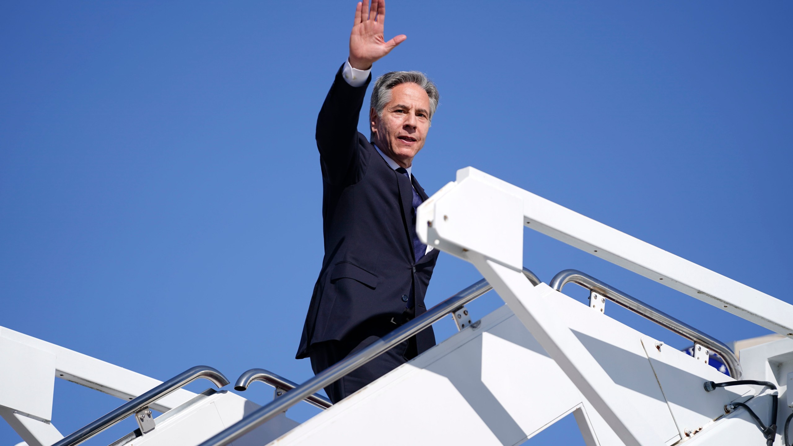 Secretary of State Antony Blinken waves as he boards a plane en route to the Middle East as he departs Joint Base Andrews, Md., Monday, Oct. 21, 2024. (Nathan Howard/Pool Photo via AP)