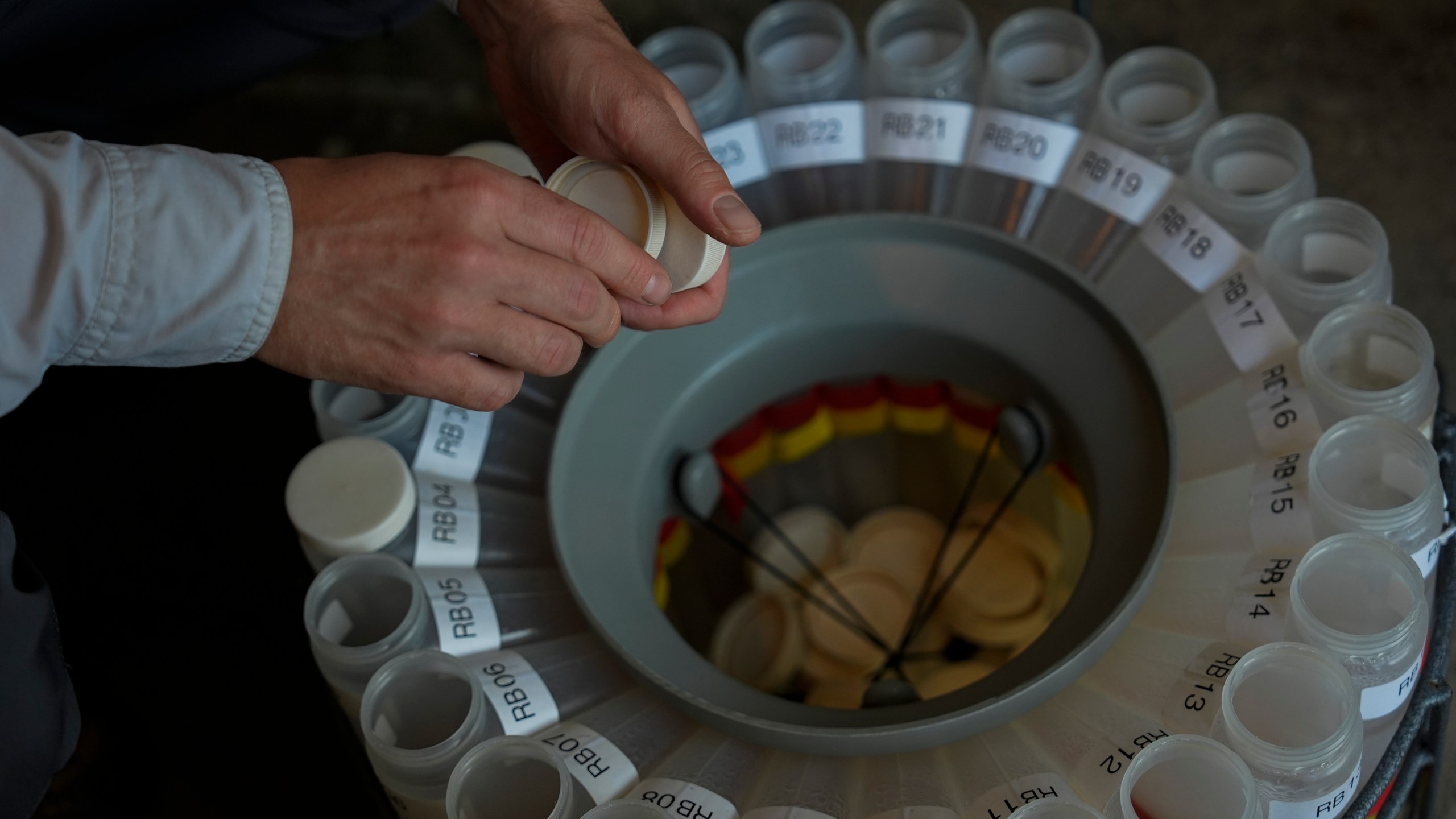 Jake Boehler, field manager at the National Center for Water Quality Research, collects water samples from a monitoring station, Monday, Aug. 26, 2024, in Woodville, Ohio. (AP Photo/Joshua A. Bickel)