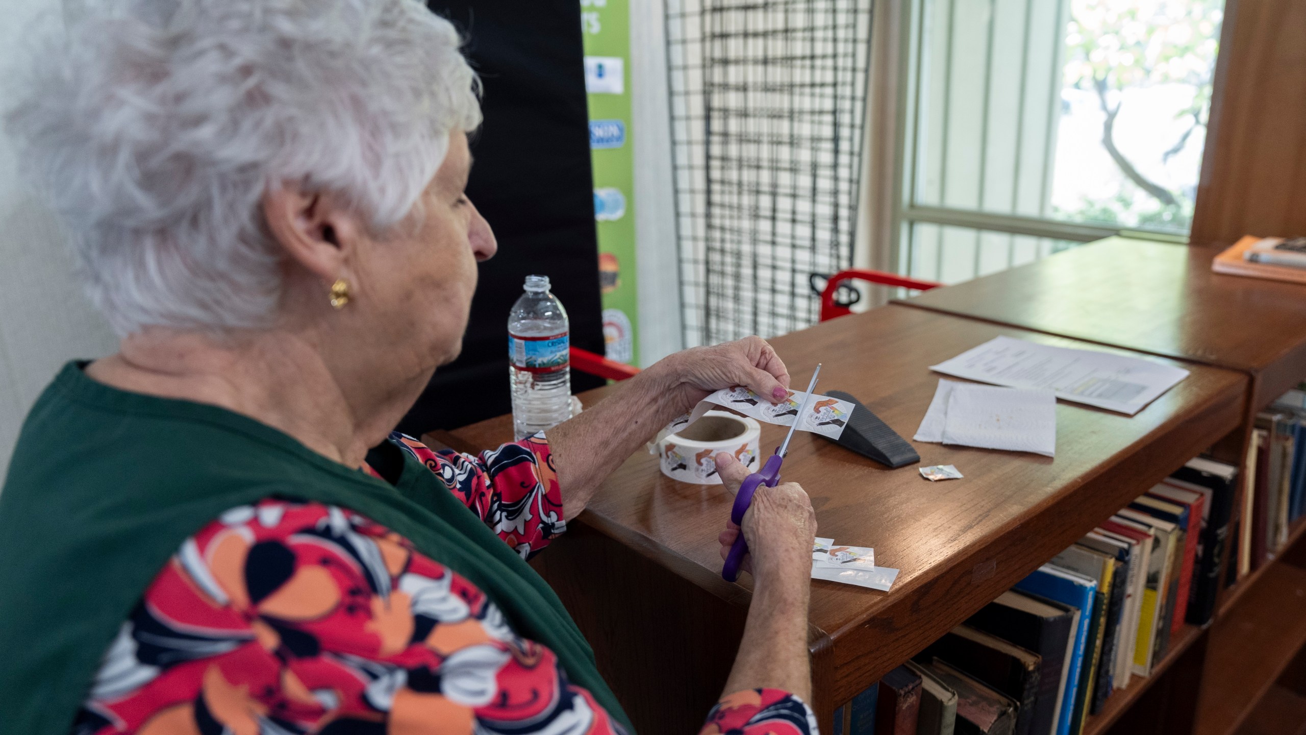 An election official prepares stickers for voters who have cast their ballots during the first day of early in-person voting in Black Mountain, N.C., Thursday, Oct. 17, 2024. (AP Photo/Stephanie Scarbrough)