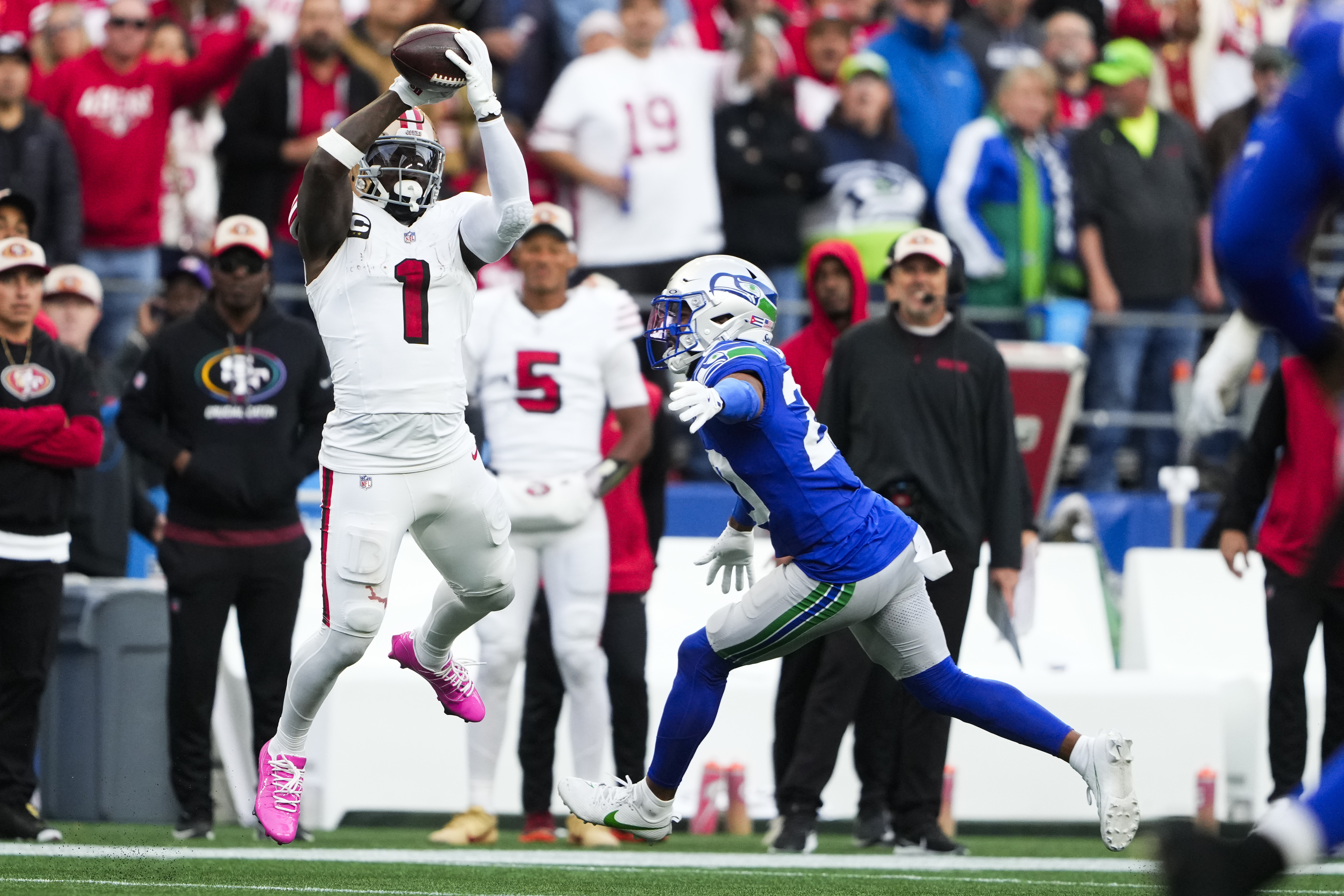 San Francisco 49ers wide receiver Deebo Samuel Sr. (1) makes a catch against Seattle Seahawks safety Julian Love, right, and would run it in for a touchdown during the first half of an NFL football game, Thursday, Oct. 10, 2024 in Seattle. (AP Photo/Lindsey Wasson)