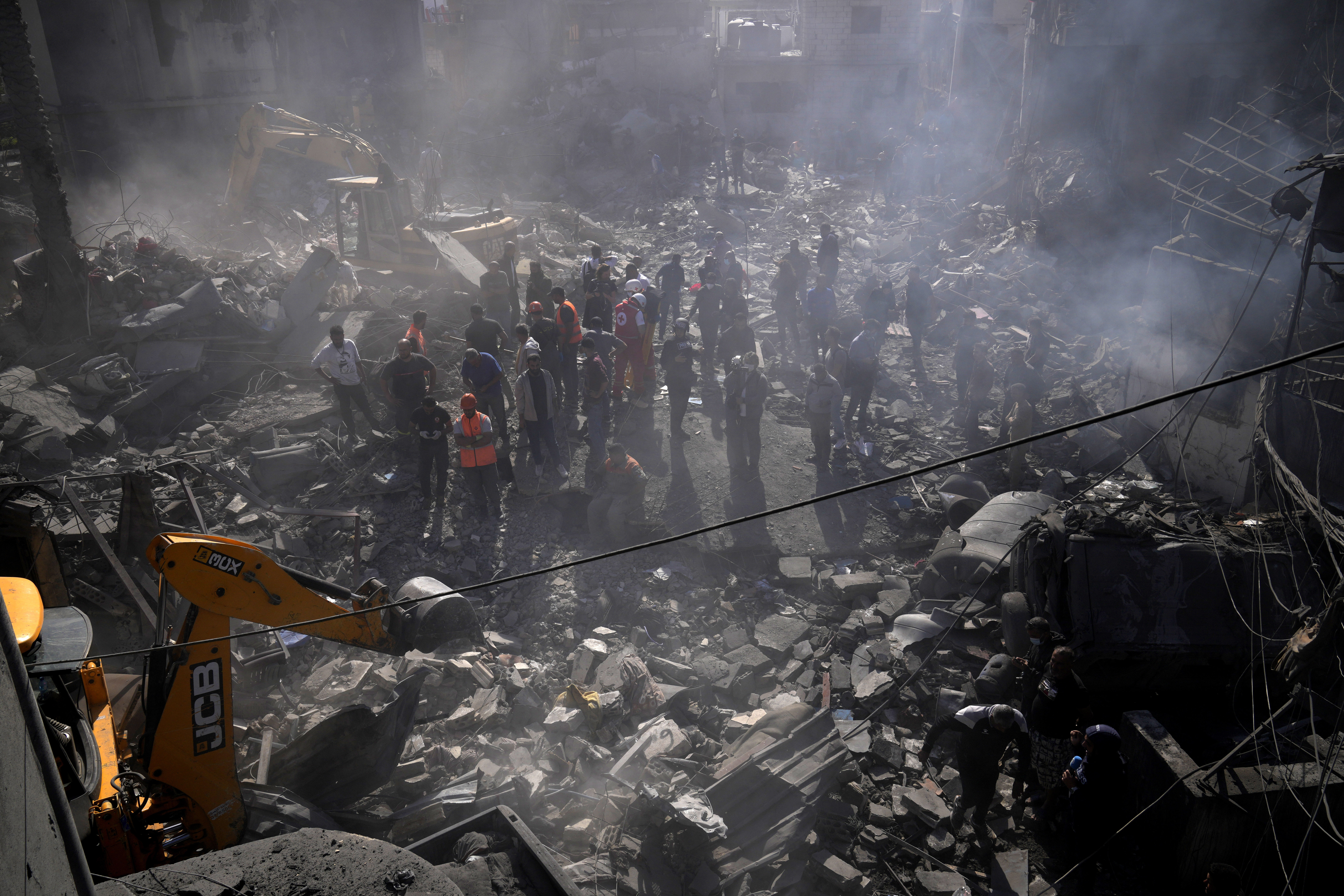 An excavator sifts through the rubble as rescue workers search for victims at the site of Israeli airstrikes that destroyed buildings, facing the city's main government hospital in a densely-populated neighborhood, in southern Beirut, Lebanon, Tuesday, Oct. 22, 2024. (AP Photo/Hussein Malla)