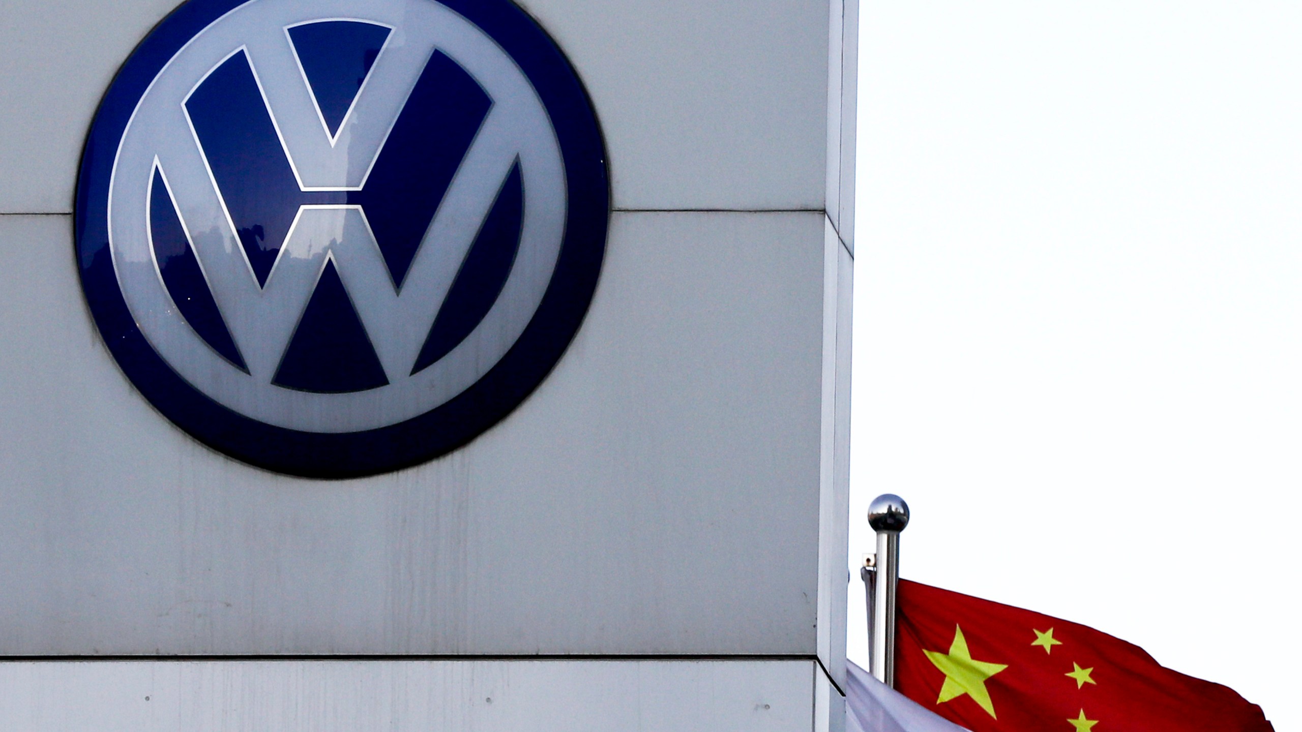 FILE - A Chinese national flag flutters near a Volkswagen logo in Beijing, Tuesday, April 18, 2017. (AP Photo/Andy Wong, File)