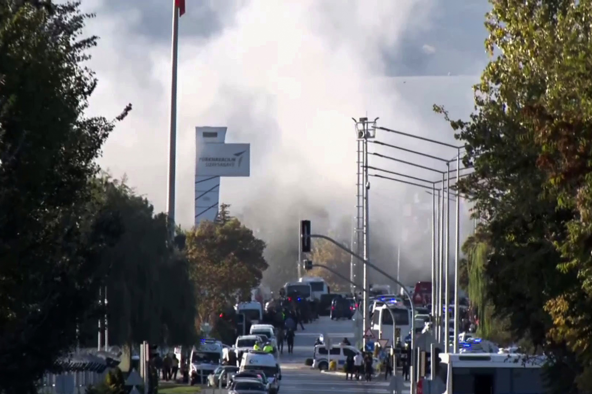 Smoke raises as emergency rescue teams and police officers attend outside Turkish Aerospace Industries Inc. on the outskirts of Ankara, Turkey, Wednesday, Oct. 23, 2024. (IHA via AP)