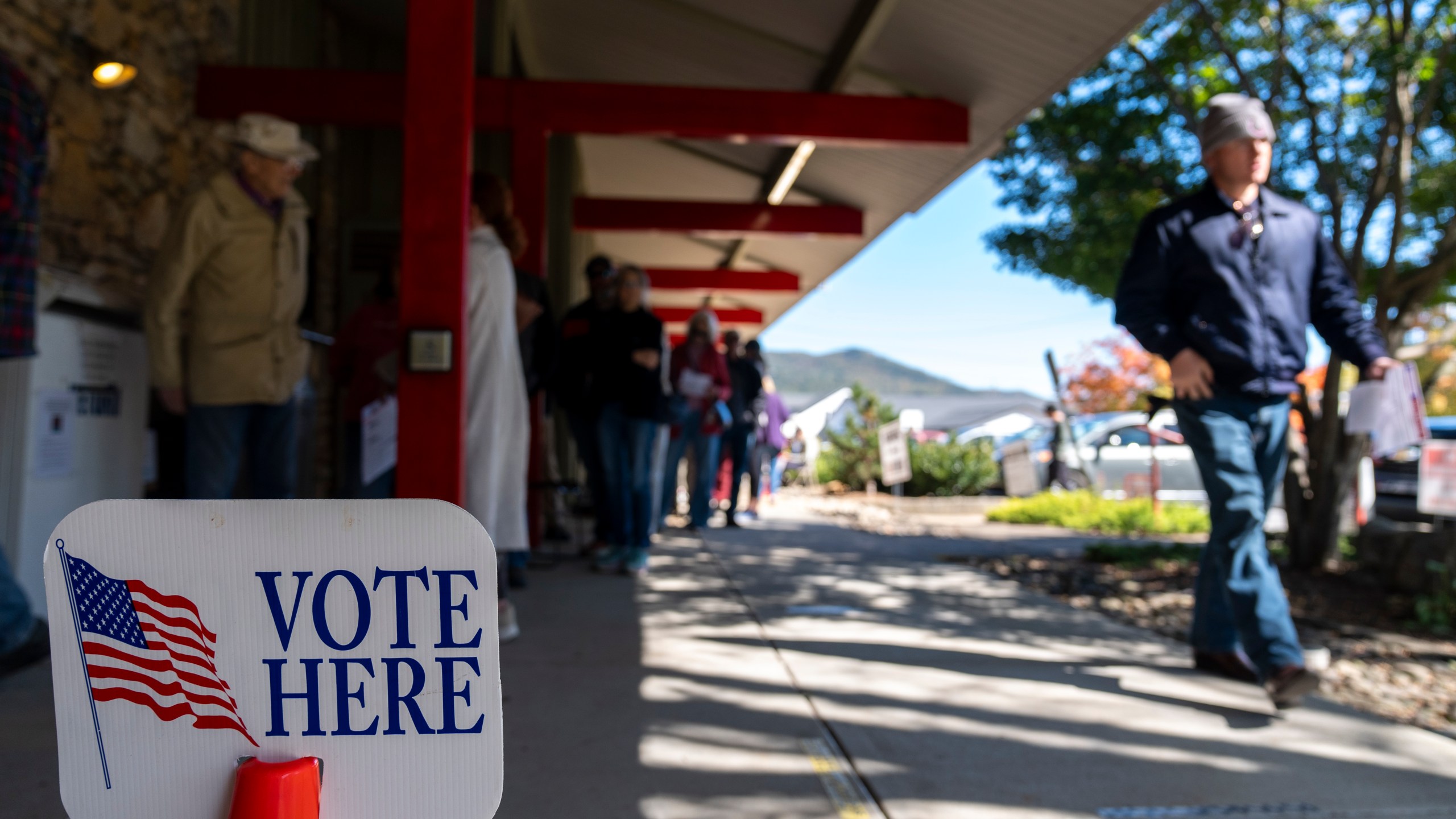 People wait in line at the polling place at Black Mountain Library during the first day of early in-person voting, on Oct. 17, 2024, in Black Mountain, N.C. (AP Photo/Stephanie Scarbrough)