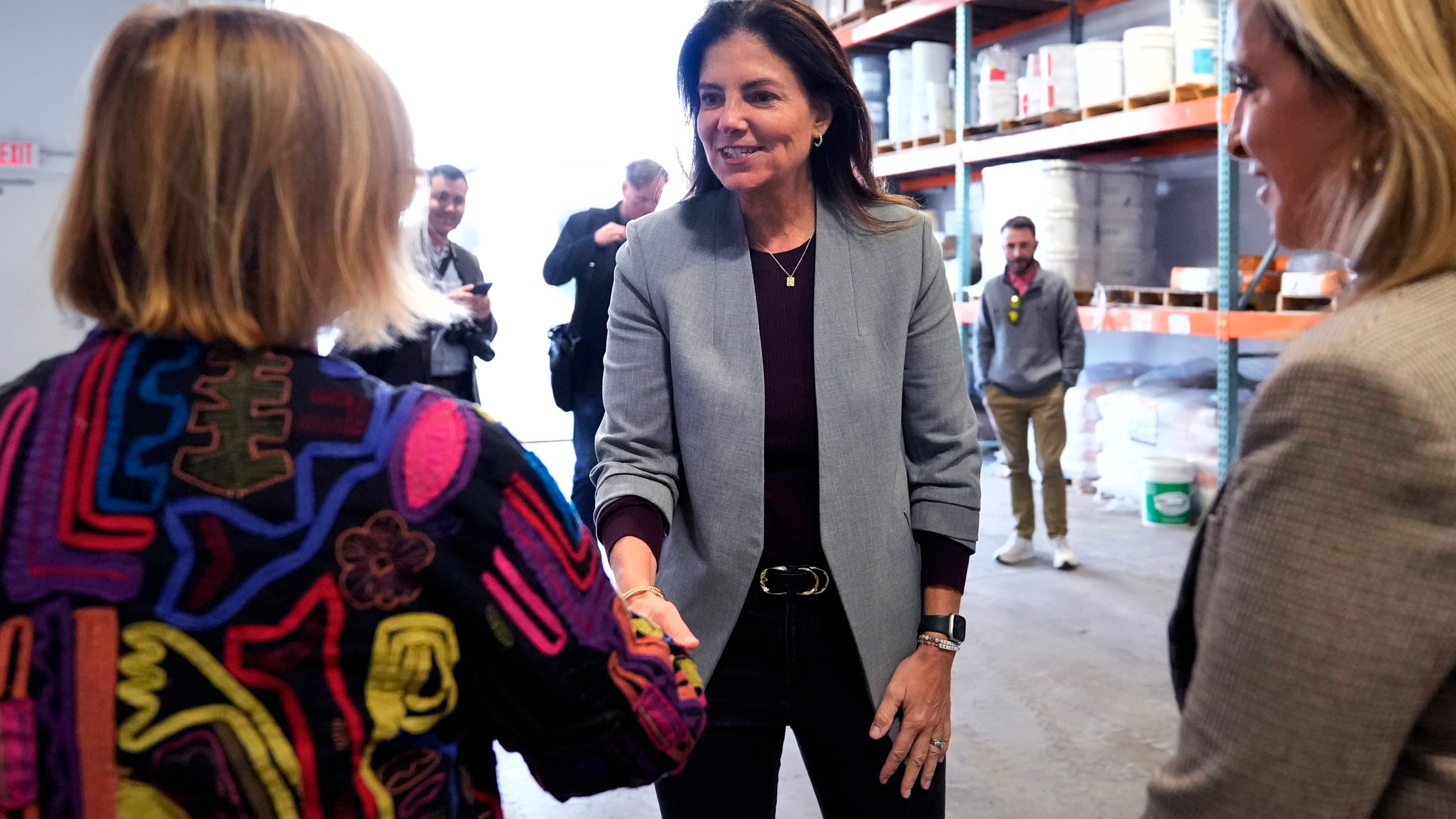 Republican gubernatorial candidate Kelly Ayotte, who faces Democrat Joyce Craig in the November 2024 election, shakes hands with administrators during a visit to a local concrete coating business, Wednesday, Oct. 16, 2024, in Manchester, N.H. (AP Photo/Charles Krupa)