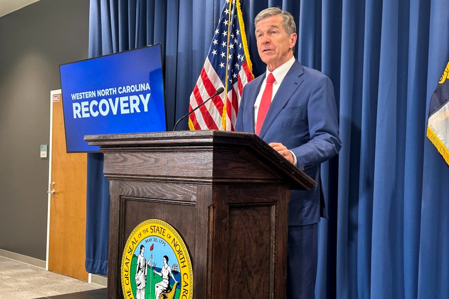 North Carolina Gov. Roy Cooper unveils a report about damages caused by Hurricane Helene and his $3.9 billion request to the General Assembly for recovery initiatives during a press conference at the Albemarle Building in Raleigh, N.C., Wednesday, Oct. 23, 2024. (AP Photo/Gary D. Robertson)