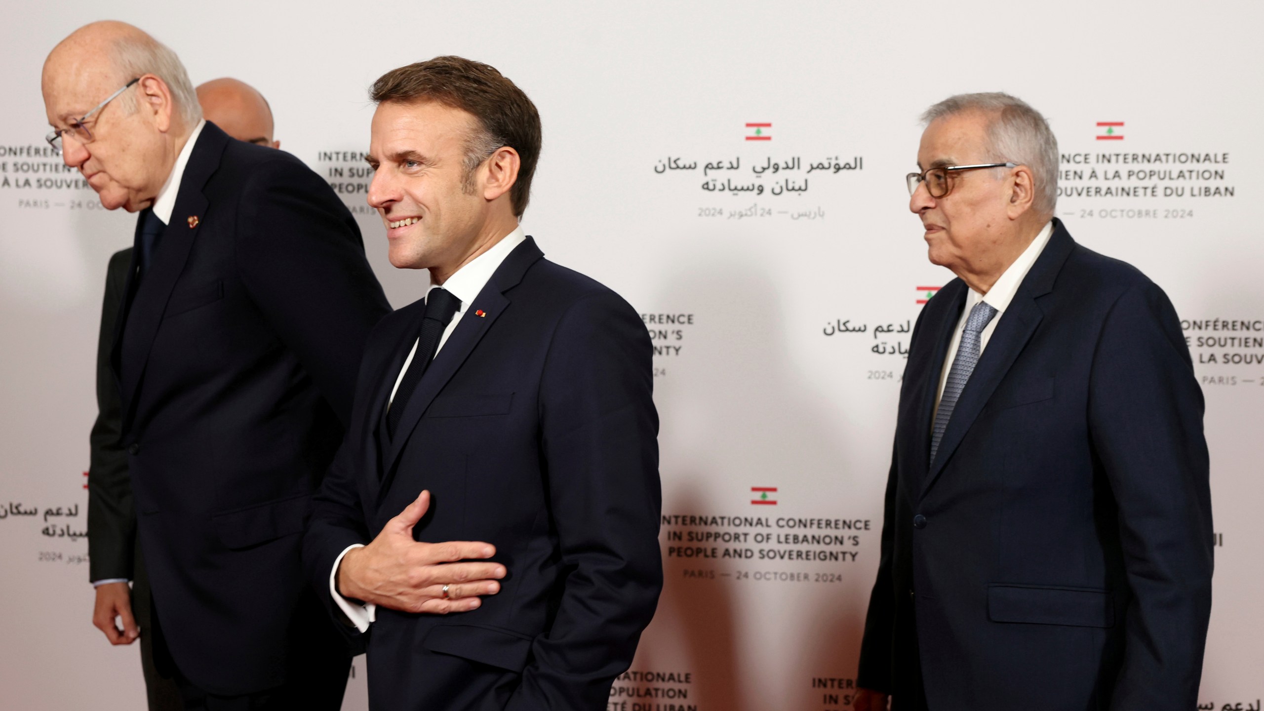 France's President Emmanuel Macron reacts next to Lebanon's Prime Minister caretaker Prime Minister Najib Mikati, left, and Lebanon's Minister of Foreign Affairs Abdallah Bou Habibas they arrive for an international press conference in support of Lebanon, in Paris, Thursday, Oct.24, 2024. (Alain Jocard, Pool via AP)