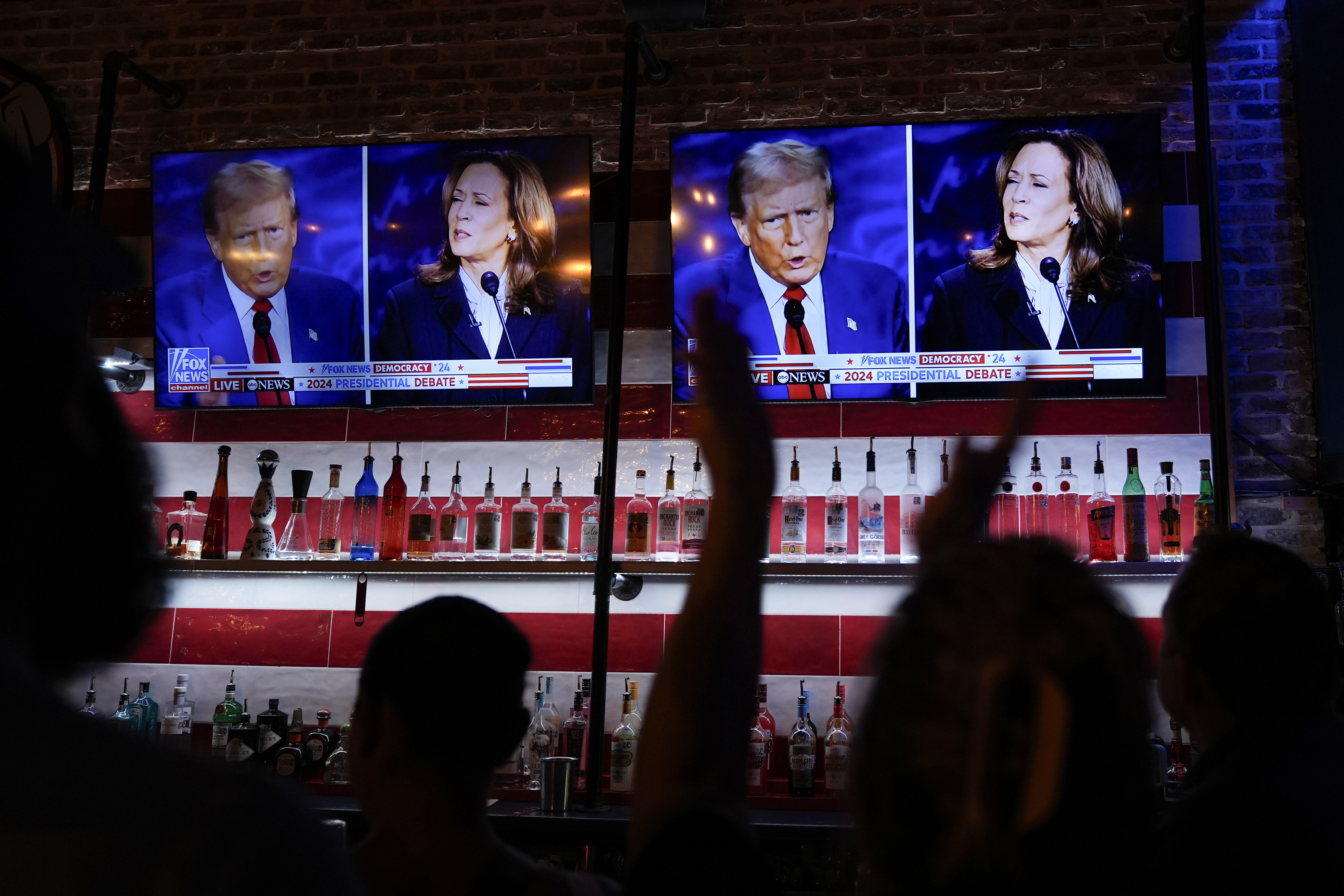 FILE - Viewers cheer as they watch a debate between Democratic presidential nominee Vice President Kamala Harris and Republican presidential nominee former President Donald Trump at the Angry Elephant Bar and Grill, Sept. 10, 2024, in San Antonio. (AP Photo/Eric Gay, File)