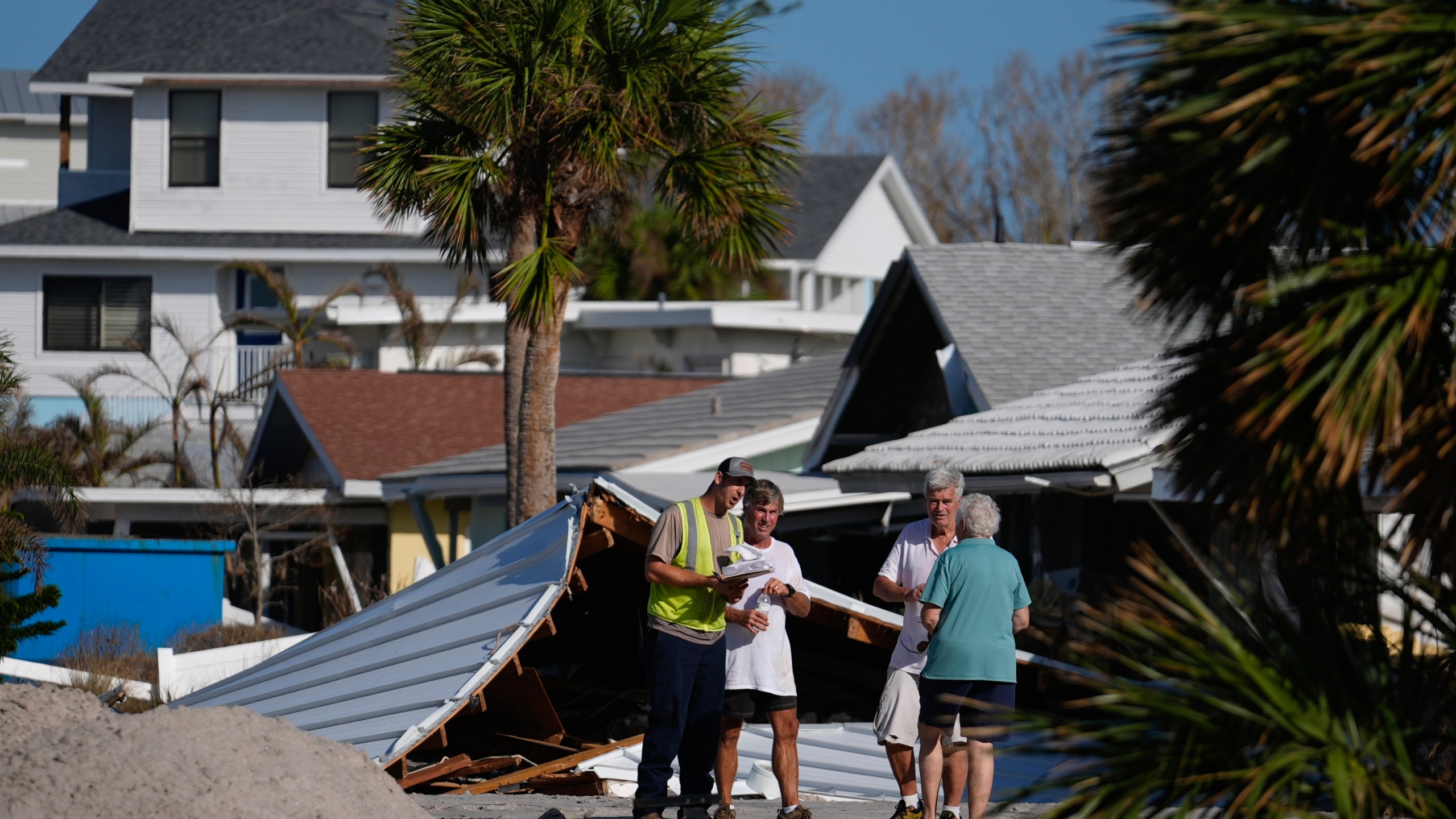 FILE - Property owners speak with an official as they process the damage to their homes and community following Hurricane Milton, on Manasota Key, in Englewood, Fla., Sunday, Oct. 13, 2024. (AP Photo/Rebecca Blackwell)