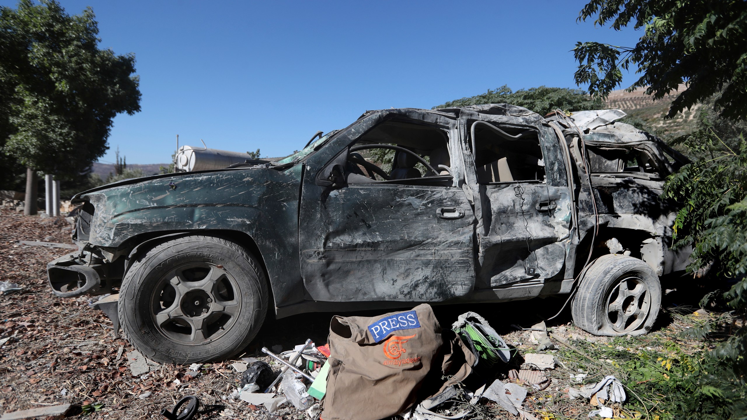 Journalists' items on the ground next to a destroyed vehicle, at the site where an Israeli airstrike hit a compound housing journalists, killing three media staffers from two different news agencies according to Lebanon's state-run National News Agency, in Hasbaya village, southeast Lebanon, Friday, Oct. 25, 2024. (AP Photo/Mohammed Zaatari)